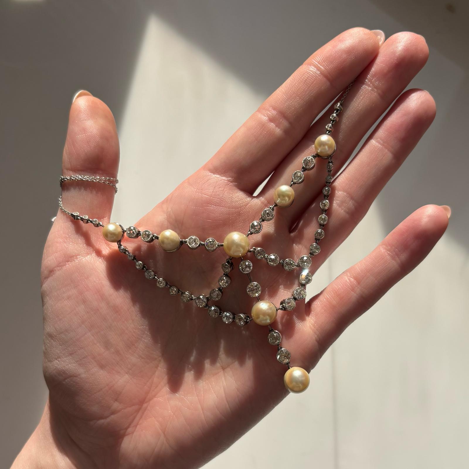 A beautiful vintage natural pearl and old cut diamond necklace set in 14k gold and platinum.

The piece features seven natural pearls and 46 old cut sparkly diamonds! The necklace currently measures 16-inches in length, but can be lengthened upon