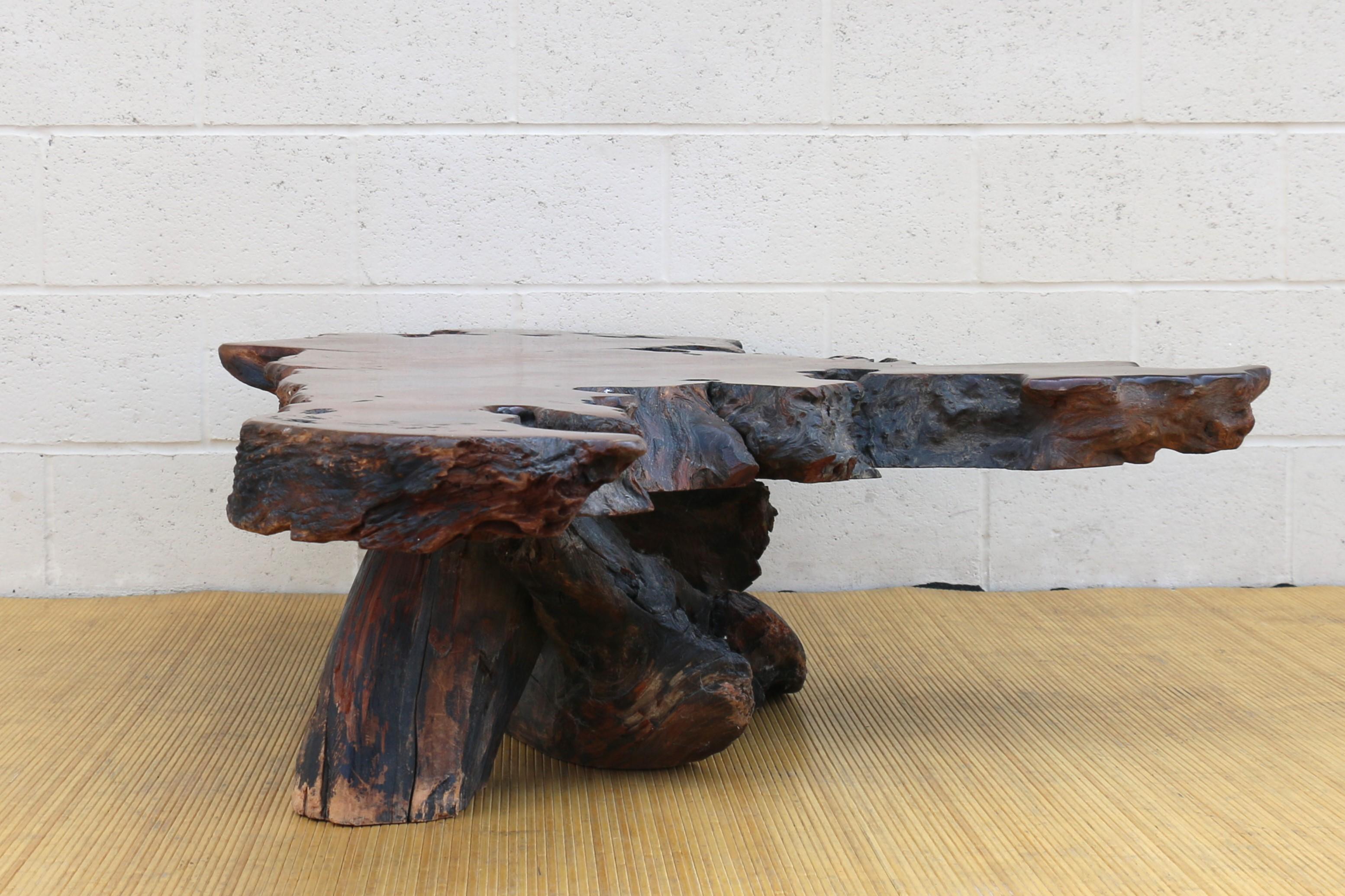 Spectaculaire table basse vintage en bois rouge avec base en souche naturelle. Cette table est un original des années 1970. Le plateau et la base sont parfaitement réalisés en bois rouge massif et il est très bien fait dans sa conception et sa