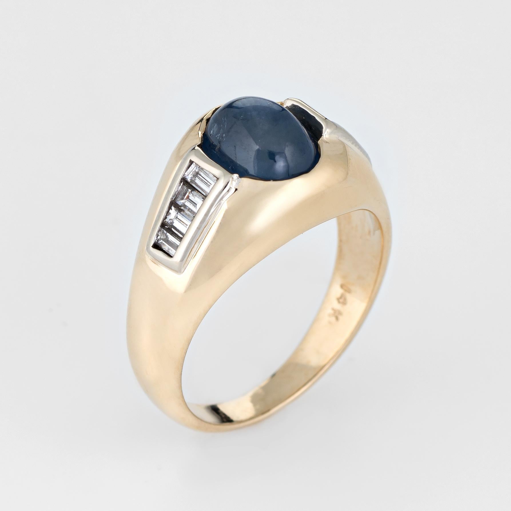 Finely detailed vintage natural sapphire & diamond ring (circa 1980s), crafted in 14 karat yellow gold. 

Natural cabochon cut blue sapphire measures 8mm x 6mm (estimated at 3 carats) is accented with an estimated 0.30 carats of straight baguette