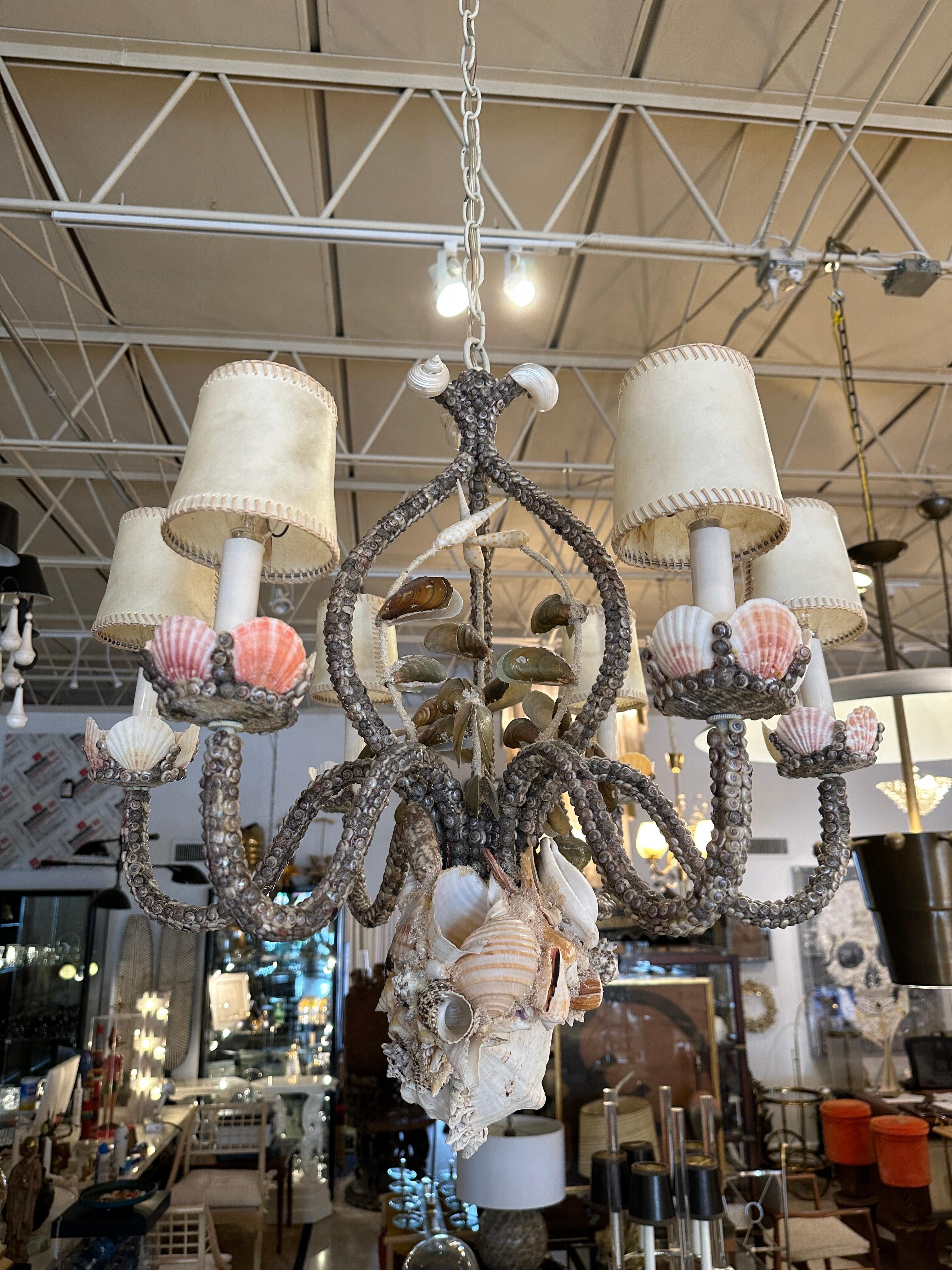 This 6-Arm Palm Beach beauty is completely encrusted with 100% natural seashells of all sorts. A gorgeous conch shell to bottom finial and ORIGINAL vintage parchment shades included. Also features original shell covered canopy.

NOTE: 66 inches