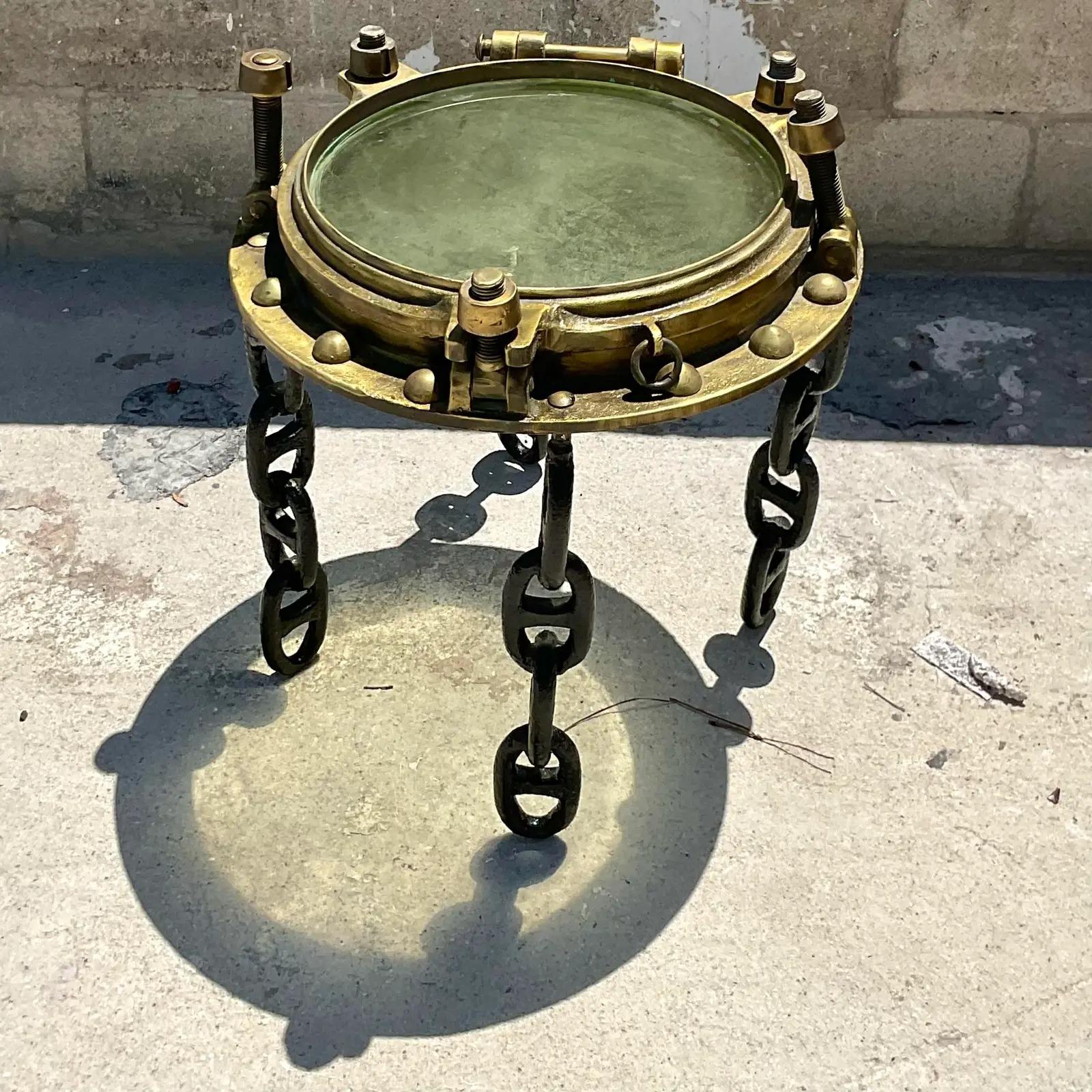 Amazing vintage Nautical side table. An original brass porthole with original glass. Supported by vintage ship chain link legs. A real collectors item. Acquired from a Palm Beach estate.