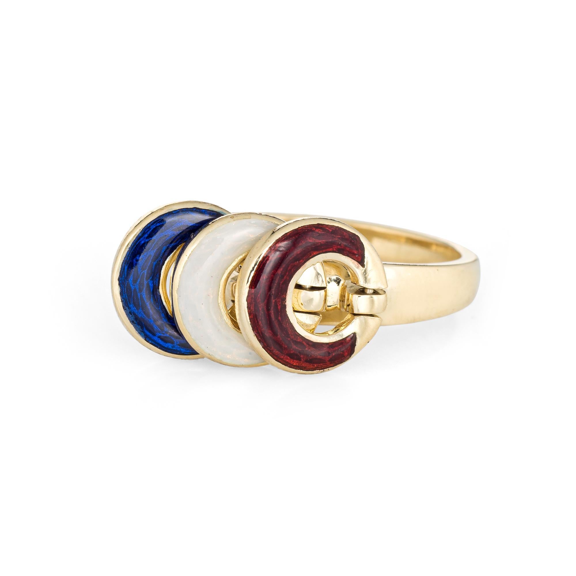 Stylish vintage enamel ring (circa 1970s to 1980s) crafted in 18 karat yellow gold. 

Red, white and blue enamel is set onto three circular mounts. The enamel is in excellent condition and free of cracks or chips. 

The ring features three movable