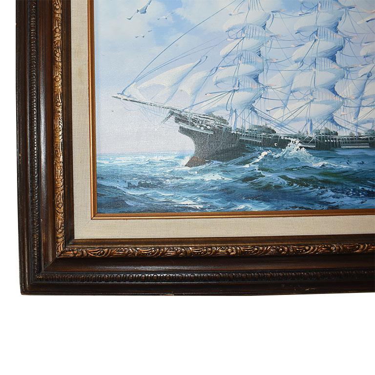 A beautifully framed vintage maritime painting of a clipper ship at sea. Painted on canvas, this nautical piece depicts a large wood ship at sea. All of its masts are at full sail and appear to be going at full speed in high wind. The sea beneath