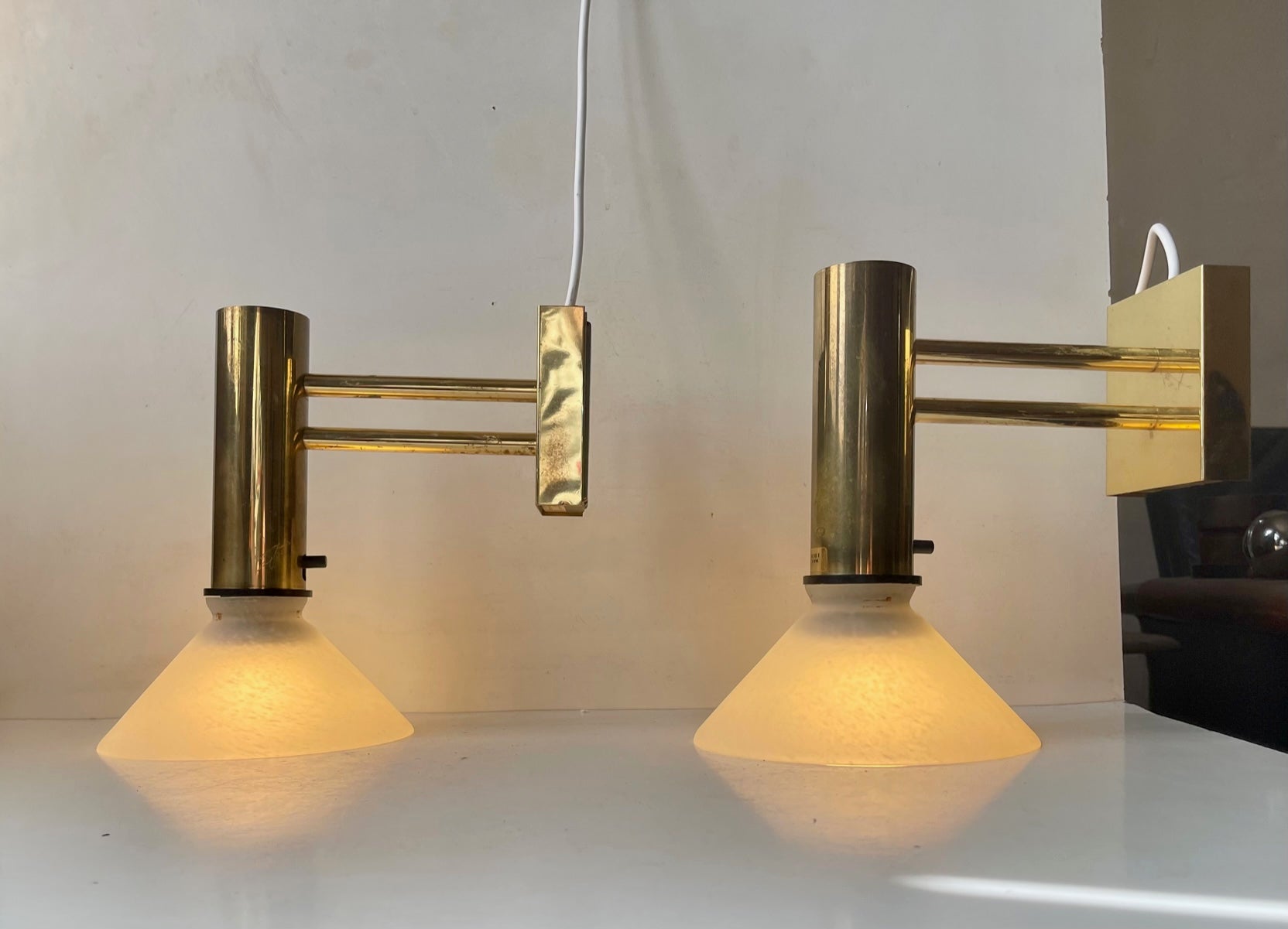 A Pair of 1970s Nautical - Navy sconces composed of brass and mounted with white textured glass shades.

For the US. The set comes installed with 110 watt adaptor plugs ready for use.