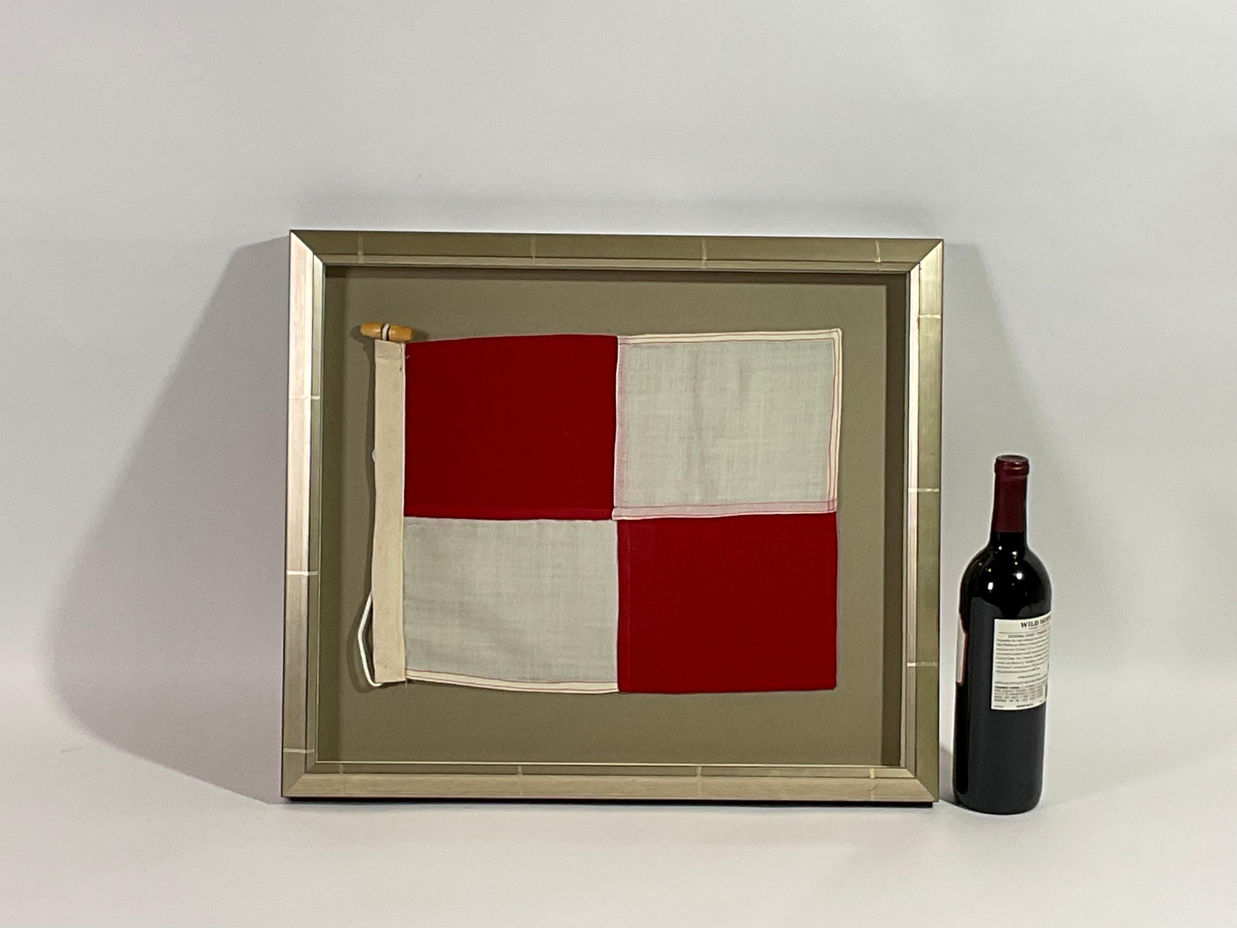 Framed maritime signal flag representing the letter “U” in the international code of signals. This authentic pennant is made of individual panels of red and white cotton. Fitted to a heavy canvas hoist band with original rope and toggle. This