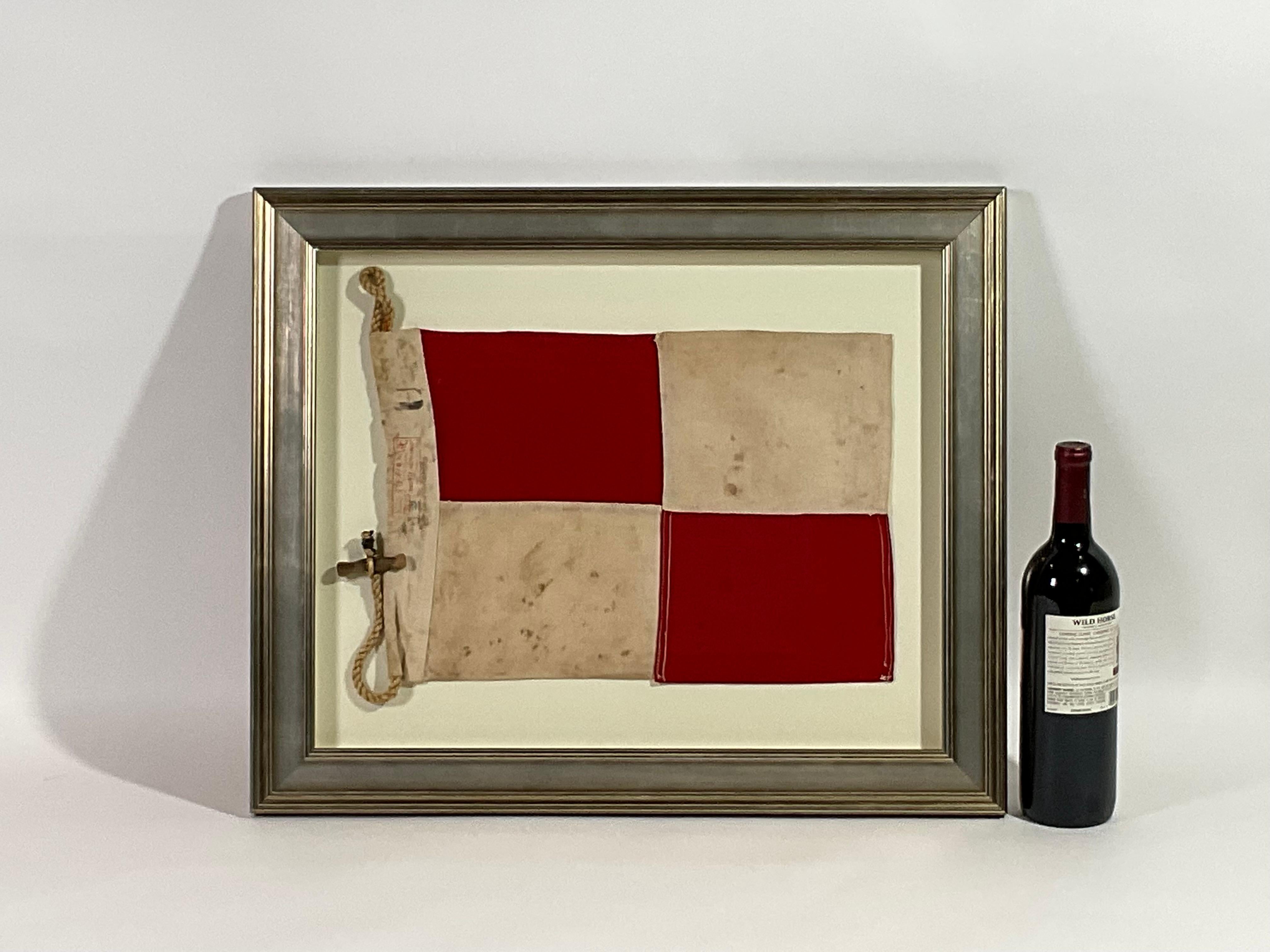 Framed maritime signal flag representing the letter “U” in the international code of signals.  This authentic and ocean used pennant is made of individual panels of red and white cotton. Fitted to a heavy canvas hoist band with original rope and