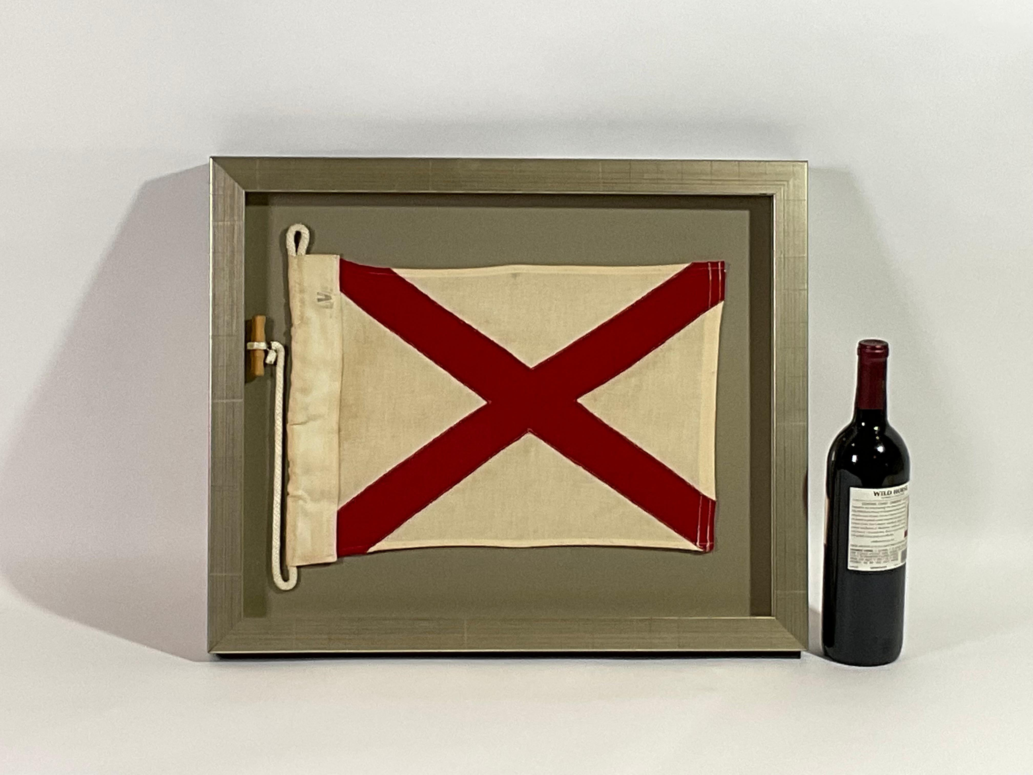Framed maritime signal flag representing the letter “V” in the international code of signals.  This authentic and ocean used pennant is made of individual panels of red and white cotton. Fitted to a heavy canvas hoist band with original rope and