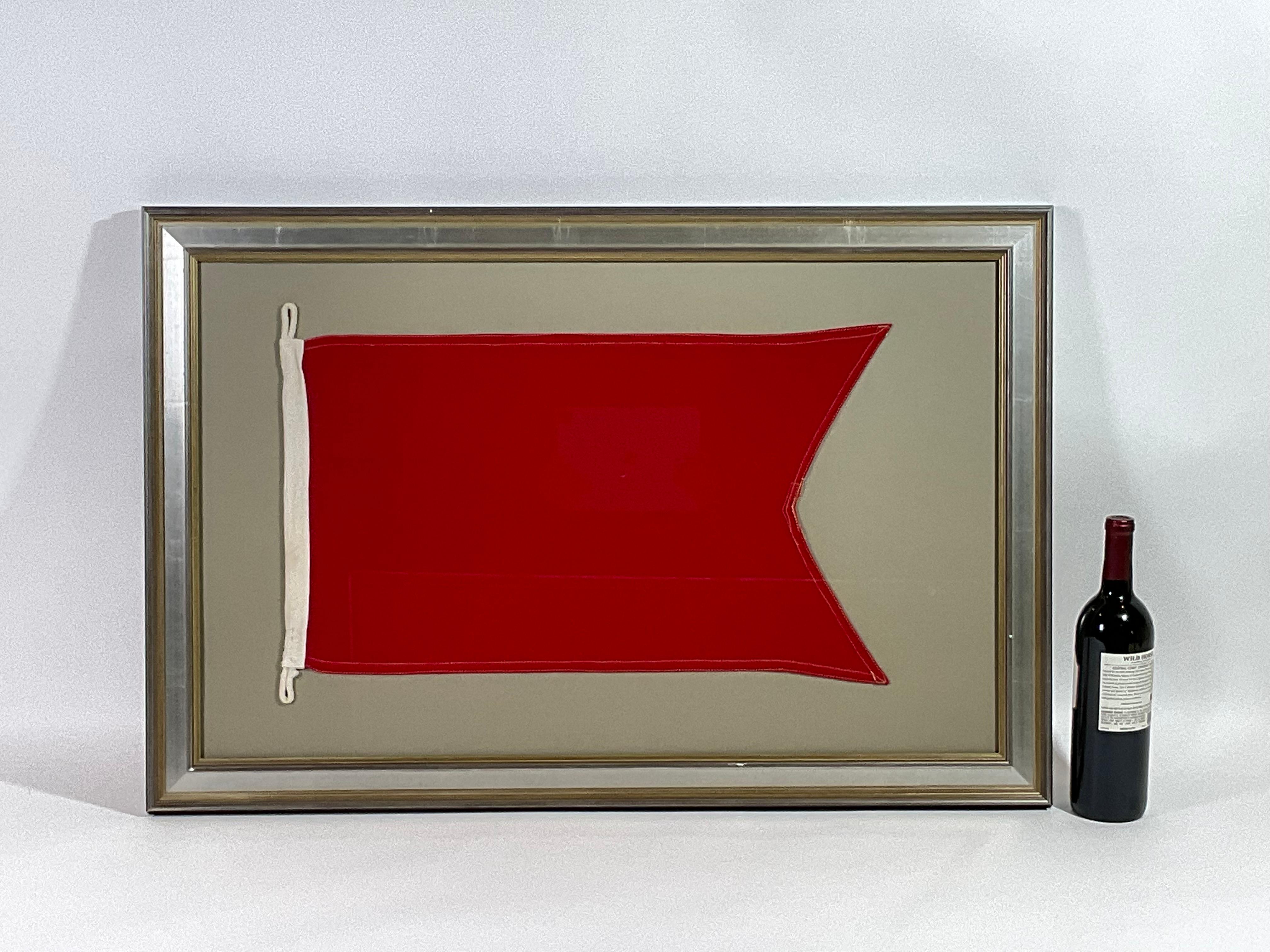 Framed maritime signal flag representing the letter “B” in the international code of signals. This authentic and ocean used pennant is made of an individual panel of red. Fitted to a heavy canvas hoist band with rigging tabs. This nautical relic is