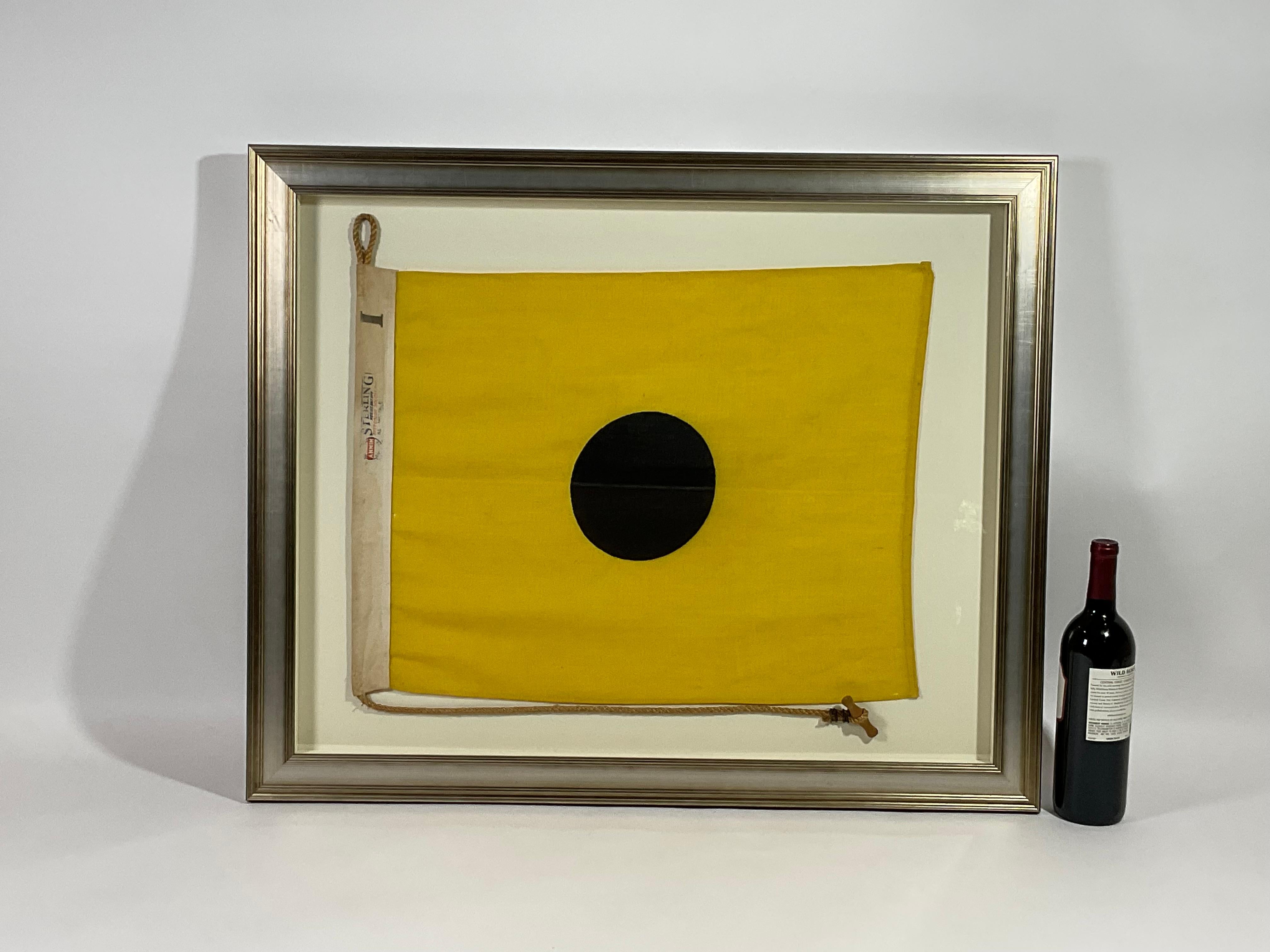 Framed maritime signal flag representing the letter “I”, “INDIA” in the international code of signals. This authentic and ocean used pennant is made of individual panels of yellow and black. Fitted to a heavy canvas hoist band with original rope and