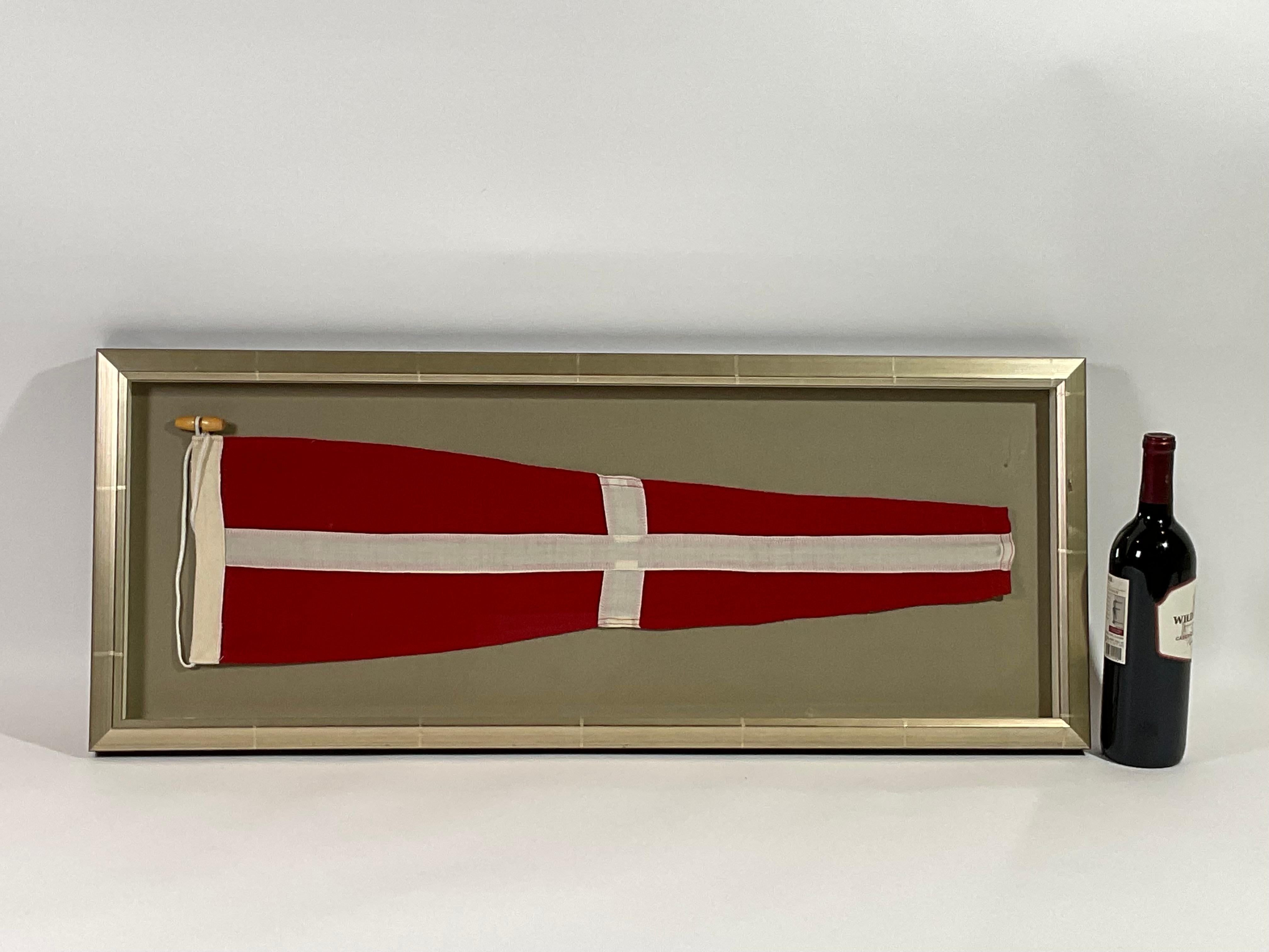 Framed maritime signal flag representing the number “4”, “FOUR” in the international code of signals. This authentic pennant is made of individual panels of red and white. Fitted to a heavy canvas hoist band with original cord and wood toggle. This