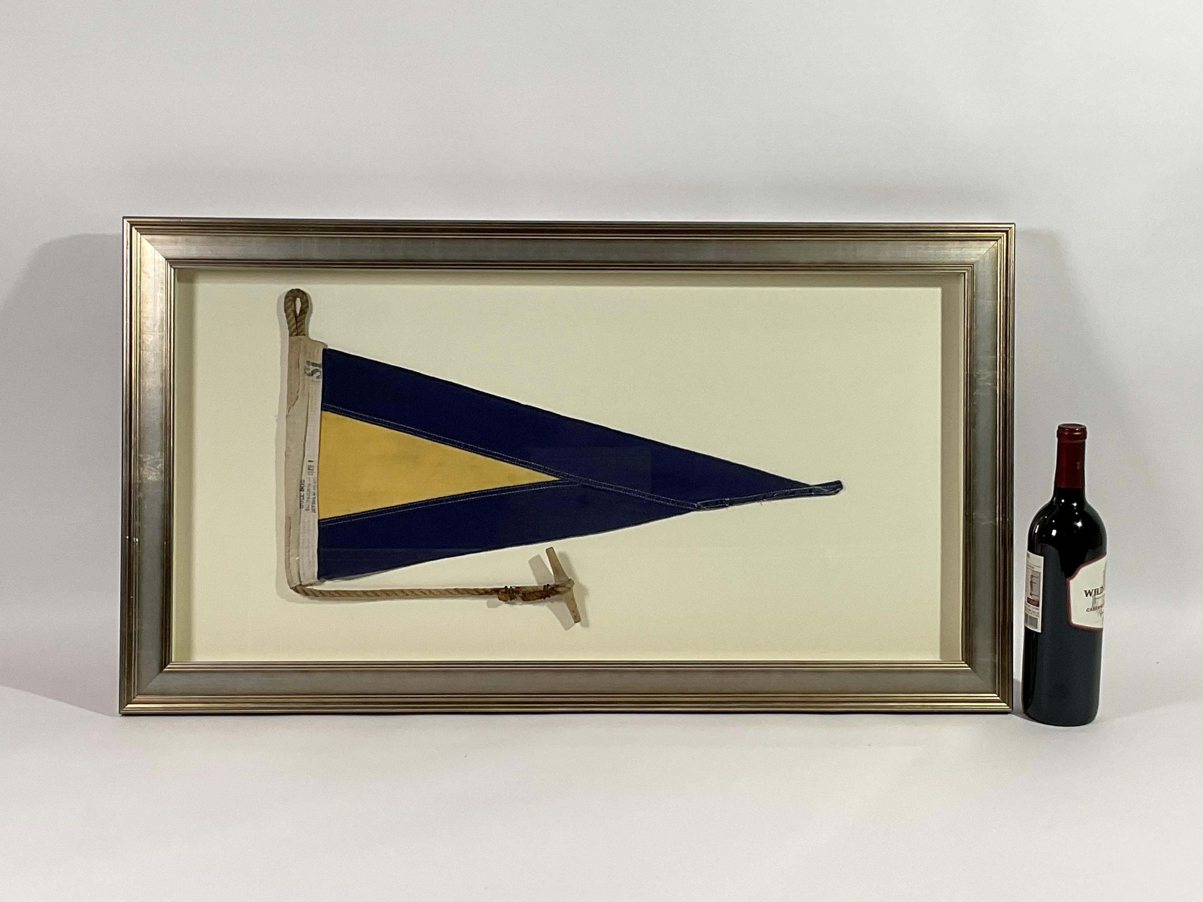 Framed maritime signal flag representing “SUBSTITUTE 1” in the international code of signals. This authentic and ocean used pennant is made of individual panels of yellow and blue. Fitted to a heavy canvas hoist band with original rope and wood