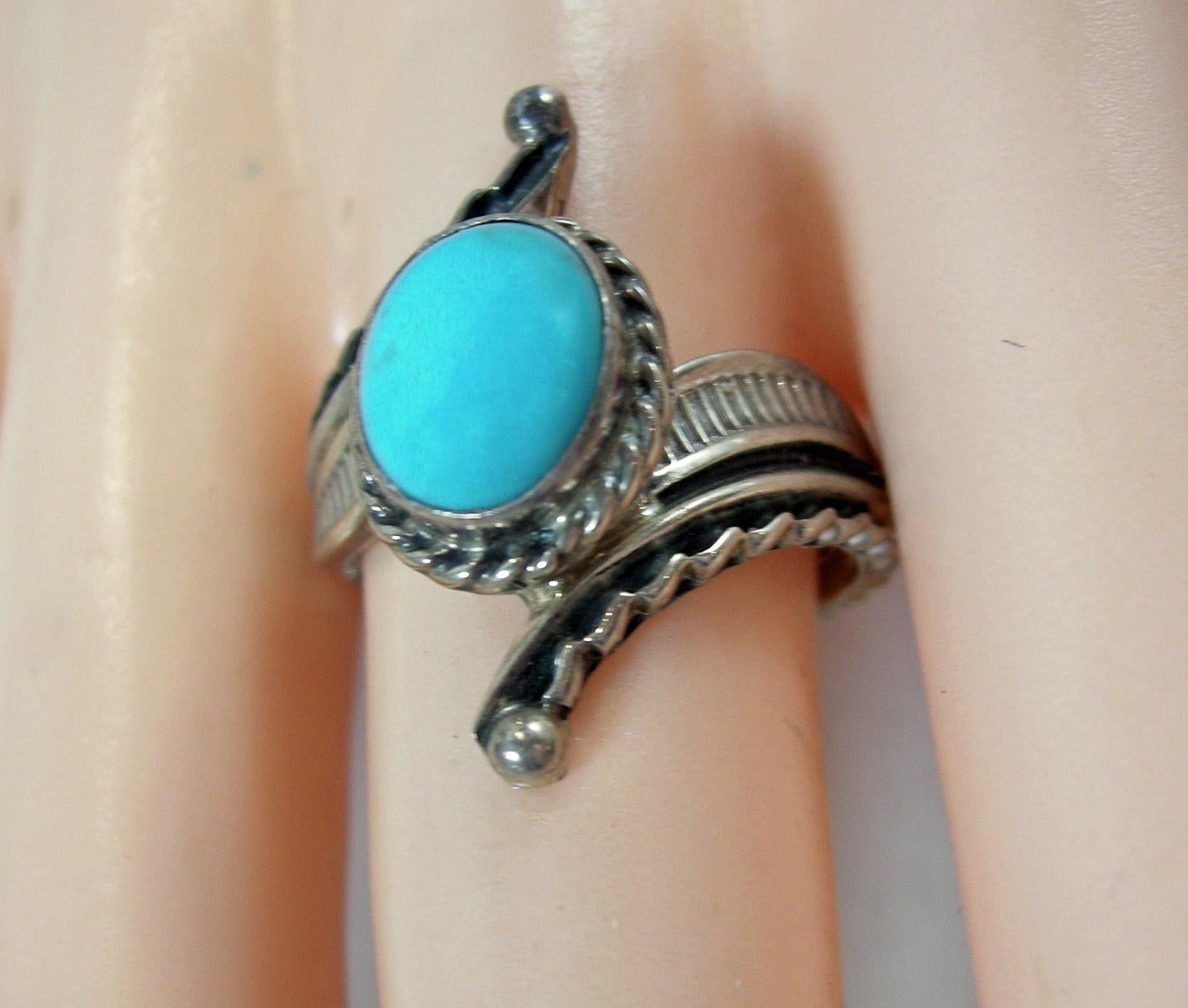 This vintage Navajo-American Indian ring by Raymond Delgarito features a turquoise stone in a heavily carved sterling silver setting.  A size 9-1/2, this ring measures 1” wide across the top and is in excellent condition.