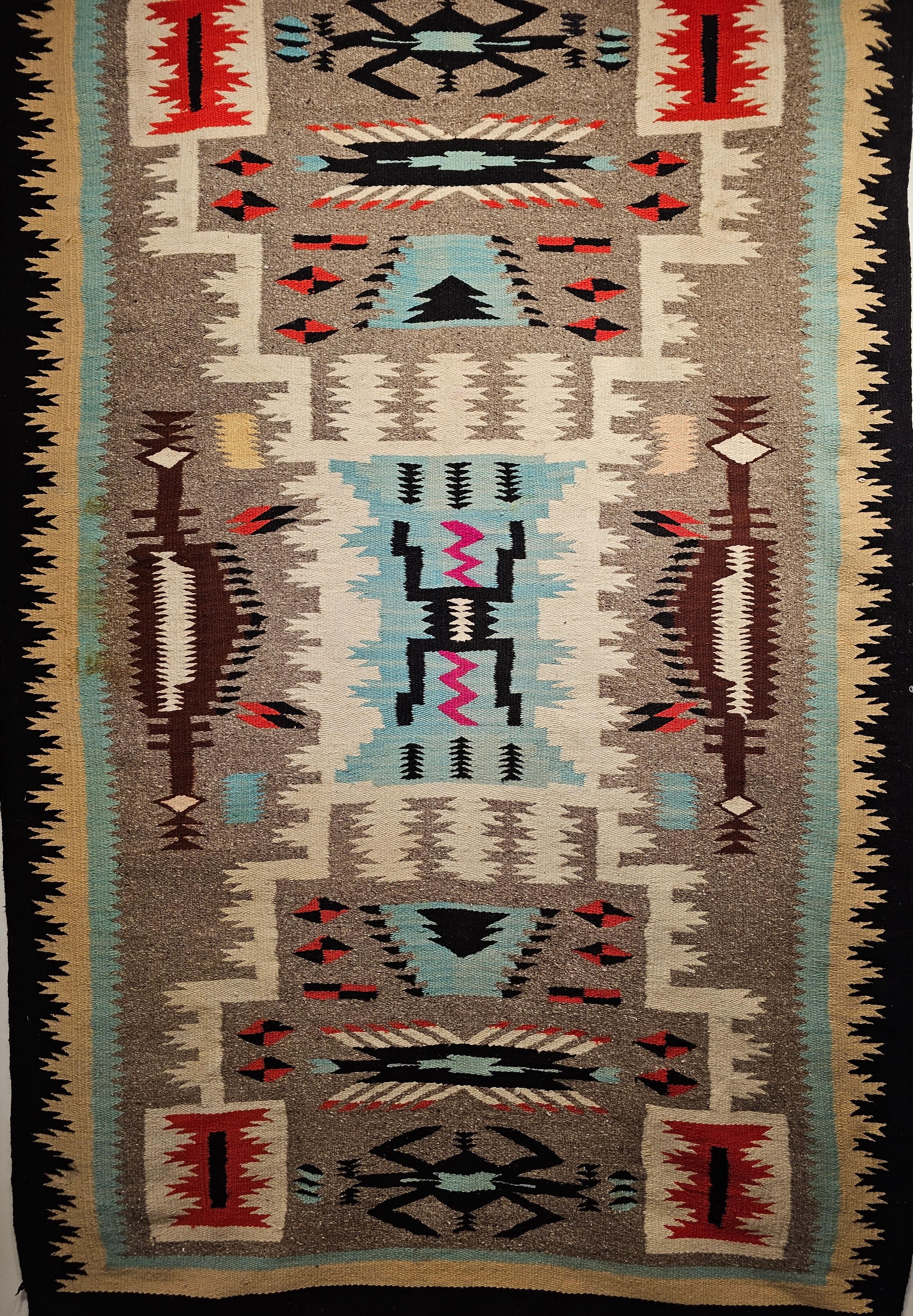Tapis vintage Navajo d'Amérique du Nord avec un design de guerrier de la tempête dans des couleurs turquoise, rose et marron.  Le tapis Navajo a été tissé à la main dans le sud-ouest des États-Unis et date du milieu des années 1900. Ce tapis