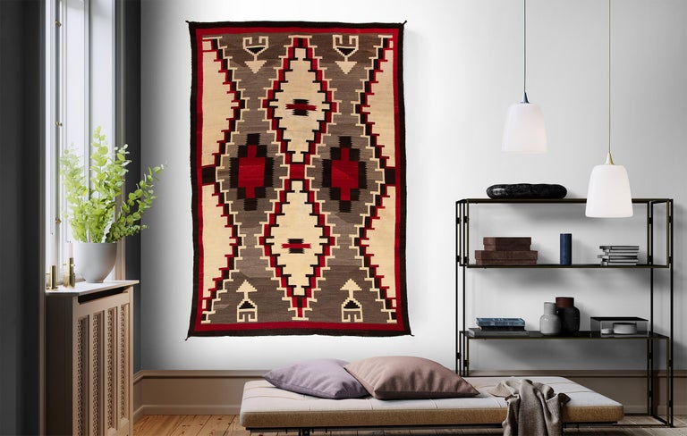 Vintage Navajo area/floor rug with a Ganado Trading Post design. Woven of native hand-spun wool in natural fleece colors of brown/black, ivory/white, grey/brown with aniline dyed red.

Textile is clean and in very good vintage