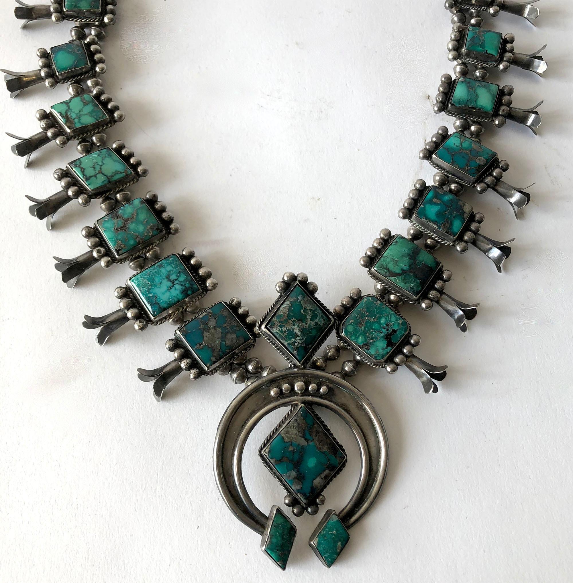 Vintage Navajo squash blossom necklace features a double strand of pearls with large pieces of turquoise, possibly Bisbee, and leaning towards green in color with natural black matrix.  Necklace measures about 26