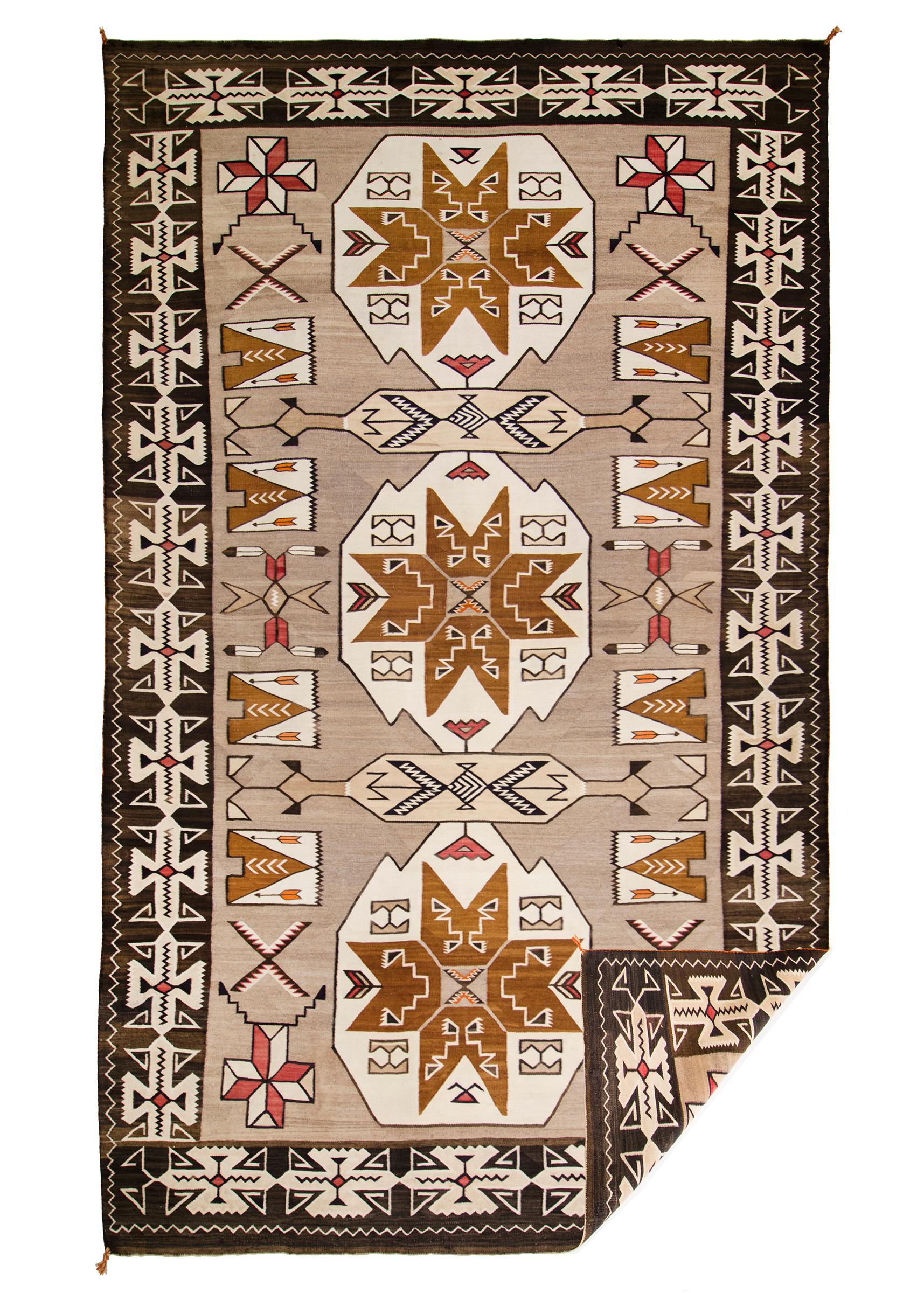 Antique Trading Post rug was woven by a Navajo weaver in a design typical of the Teec Nos Pos Trading Post/Region, native hand-spun wool in natural fleece colors of brown, black, camel and ivory with aniline dyed red. Pictorial elements include