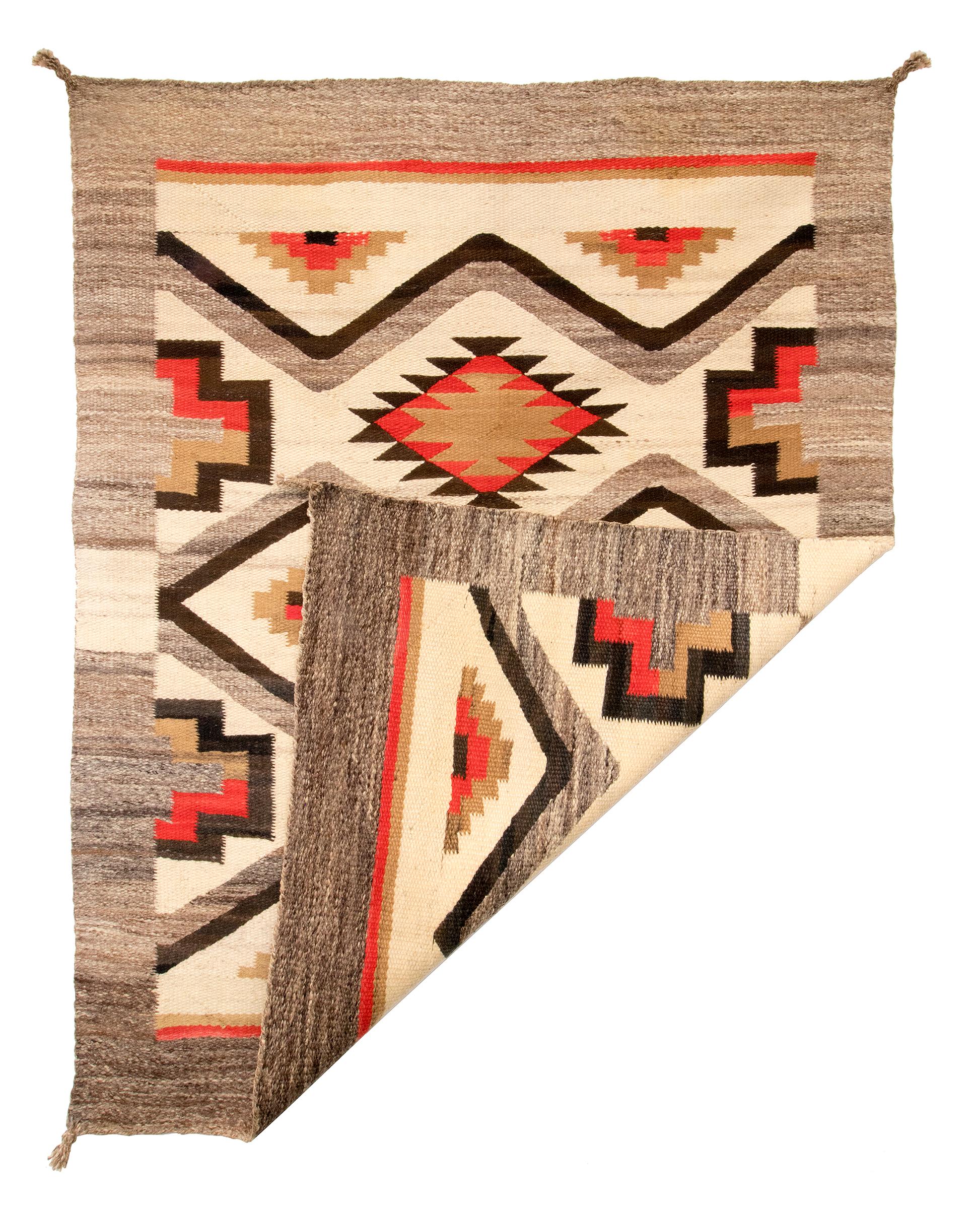 Vintage Trading Post era Navajo rug. Woven of native handspun wool in natural fleece colors of gray, ivory, dark brown and camel/beige with aniline-dyed red. Unique design frames a classic diamond and a pictorial split cross pattern with a wide