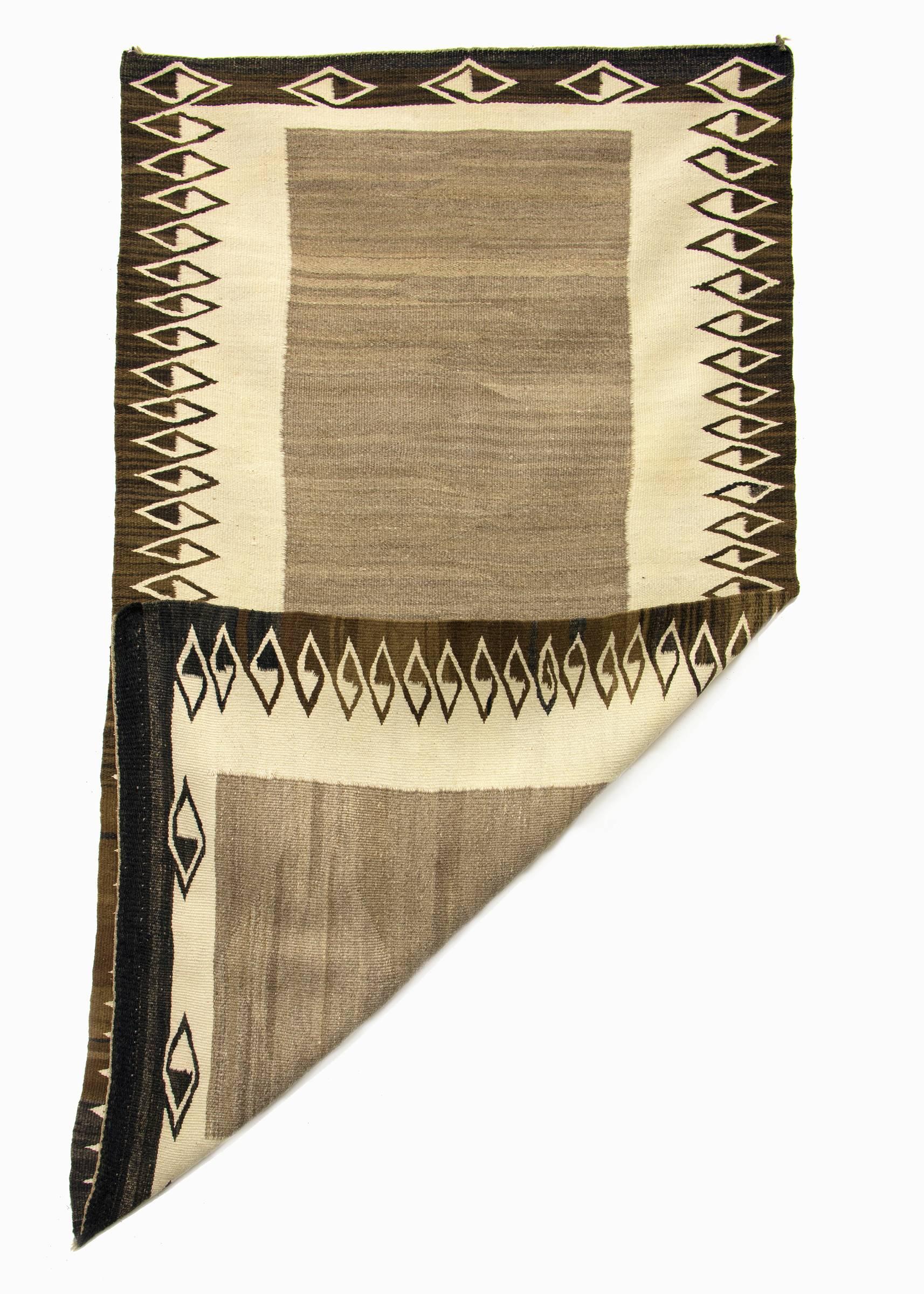 Vintage antique Navajo rug/saddle blanket circa 1900. Woven in a double saddle blanket format of native hand-spun wool in natural fleece colors of ivory, gray and brown/black.
This textile is well suited for use on the floor as an area rug or as a