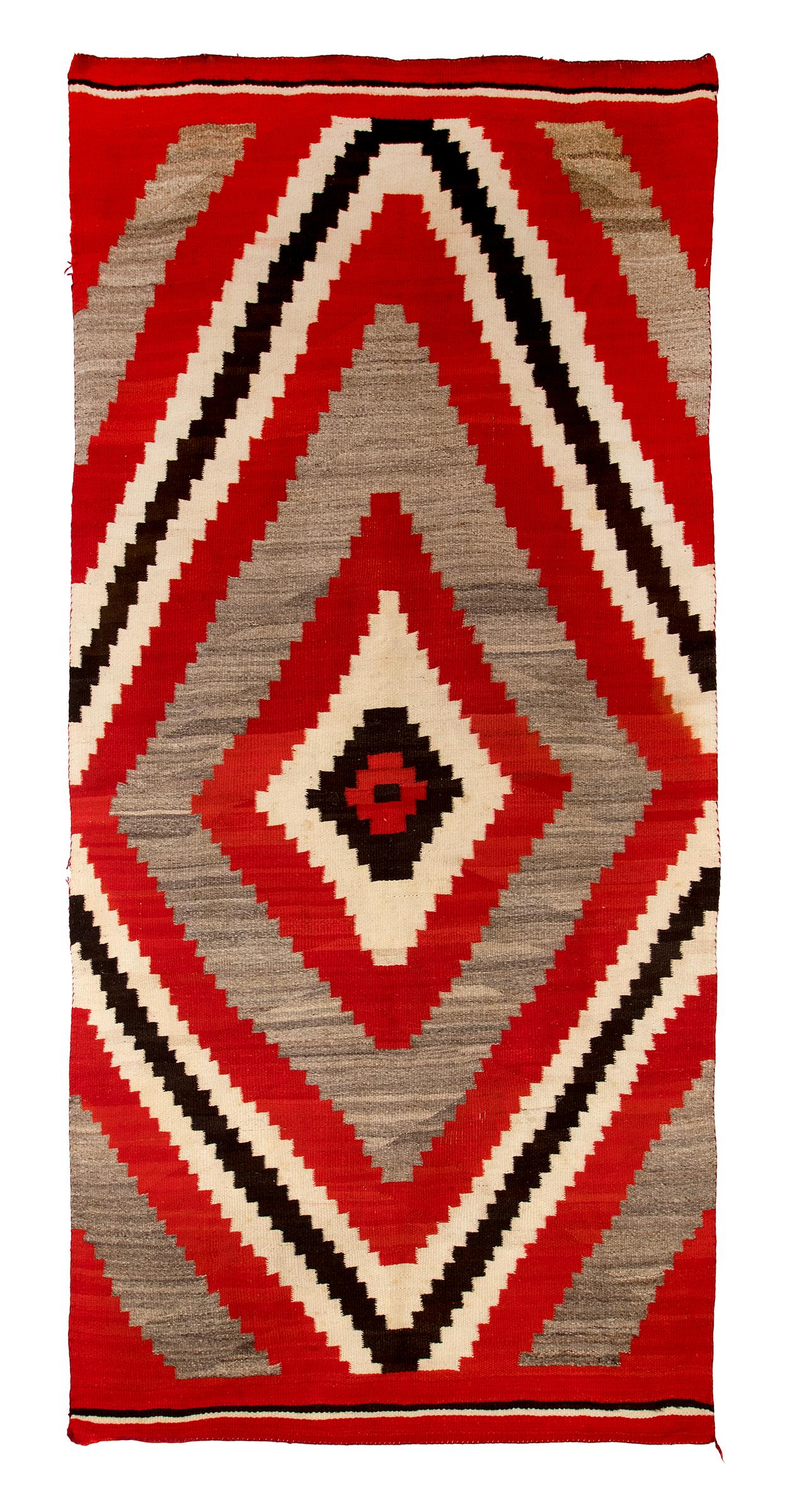 Vintage Navajo rug with a Ganado Trading Post design, circa 1900 - 1910. Woven of native hand spun wool in natural fleece colors of gray brown, ivory and brown black with aniline dyed red. Diamond pattern. This southwestern textile is well suited