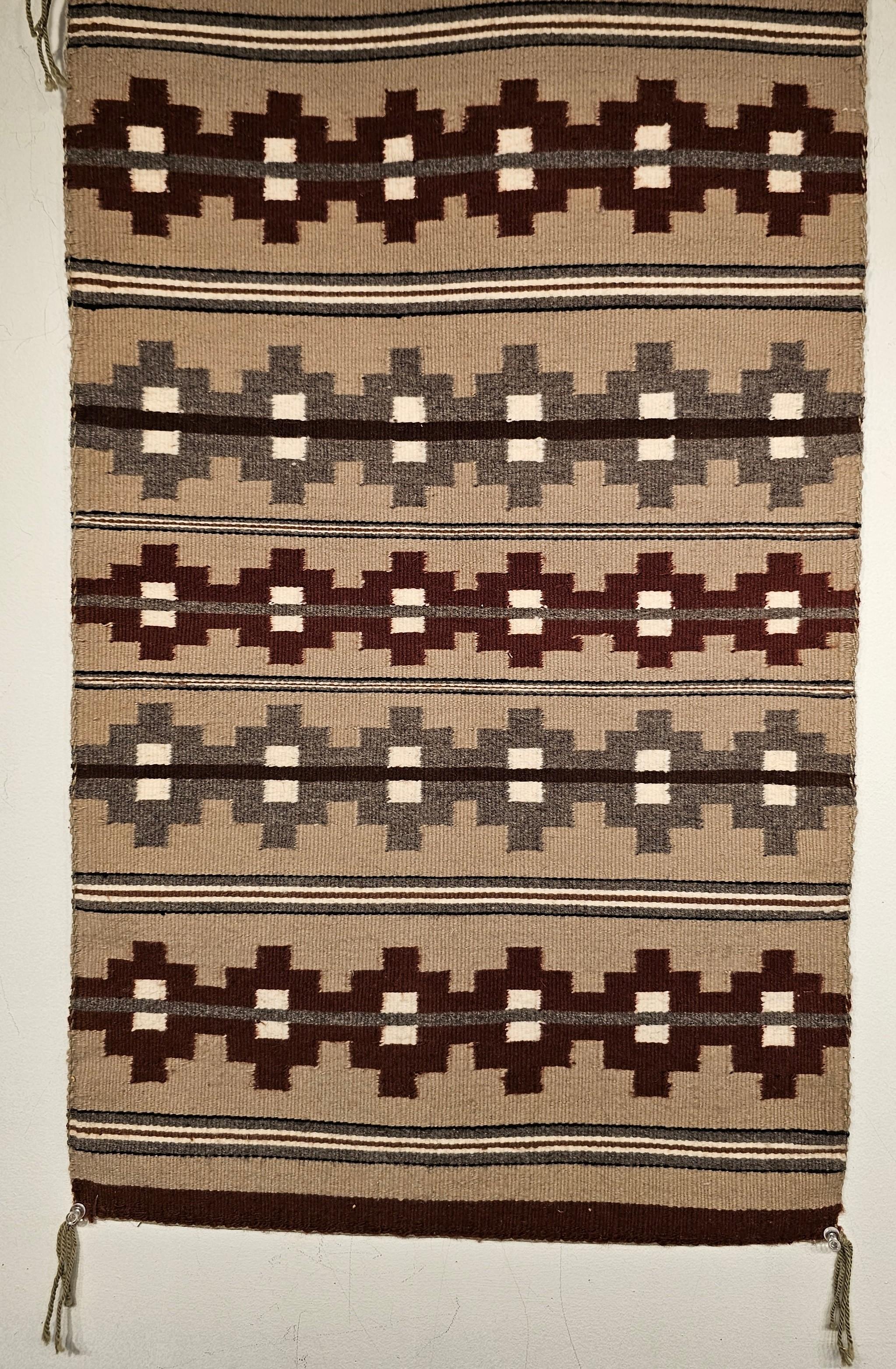 Vintage Navajo area rug with a very fine weave in a banded and stripe pattern with natural earth tones including gray, ivory, black, and caramel from the 3rd quarter of the 1900s.    The rug contains major bands with geometric design in burgundy and
