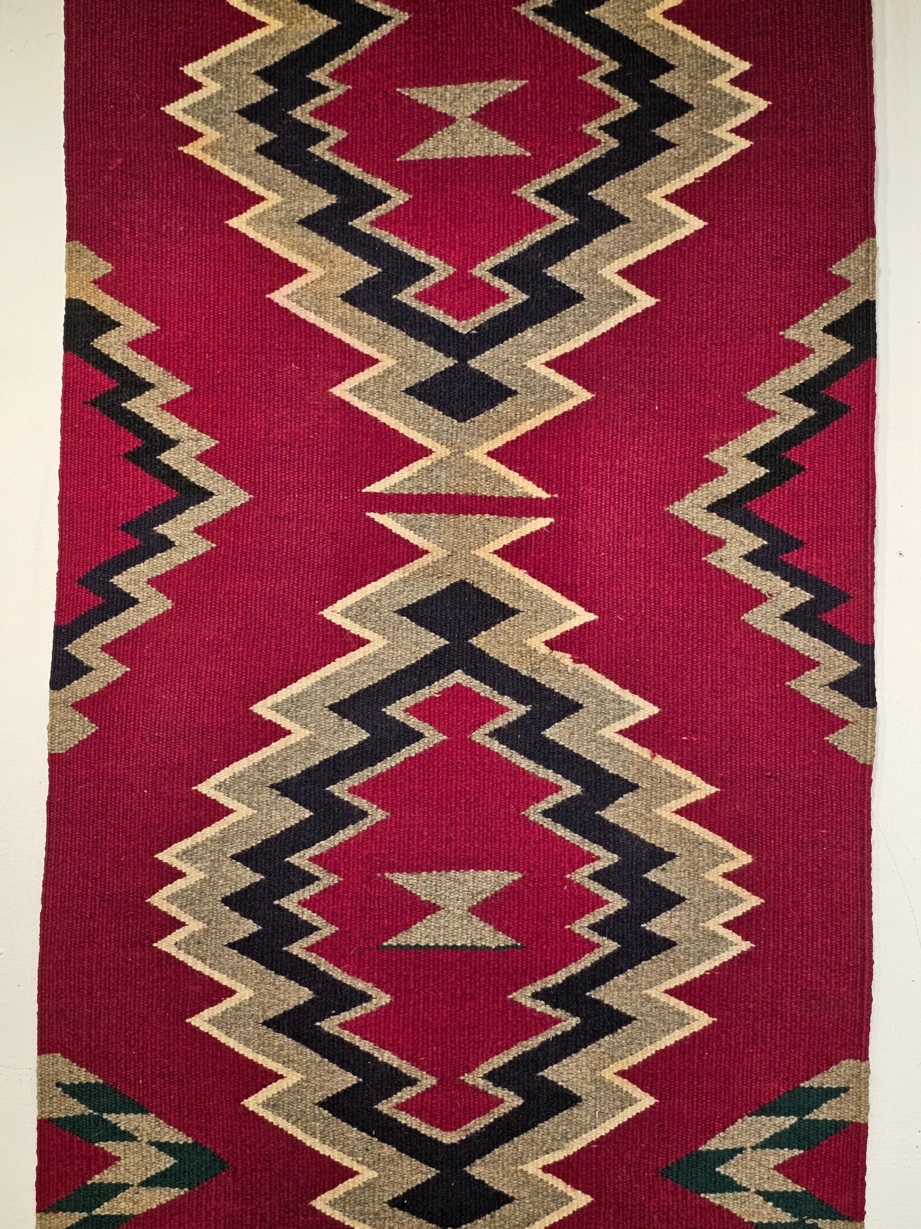 Beautiful vintage native American Navajo rug from the SW United States from the mid 1900s.    The Navajo rug has an eye dazzler medallion pattern.  The rug has a beautiful maroon-red background with two medallions in ivory, black, gray colors.  
