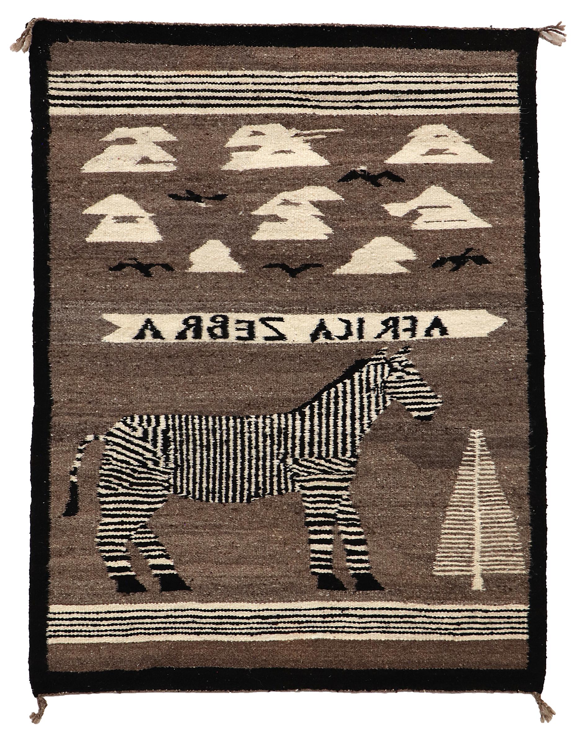 Vintage 1950s Pictorial Navajo Rug. Les éléments picturaux de ce textile tissé à la main comprennent un zèbre africain, un arbre, des nuages et des oiseaux, ainsi que les mots,  