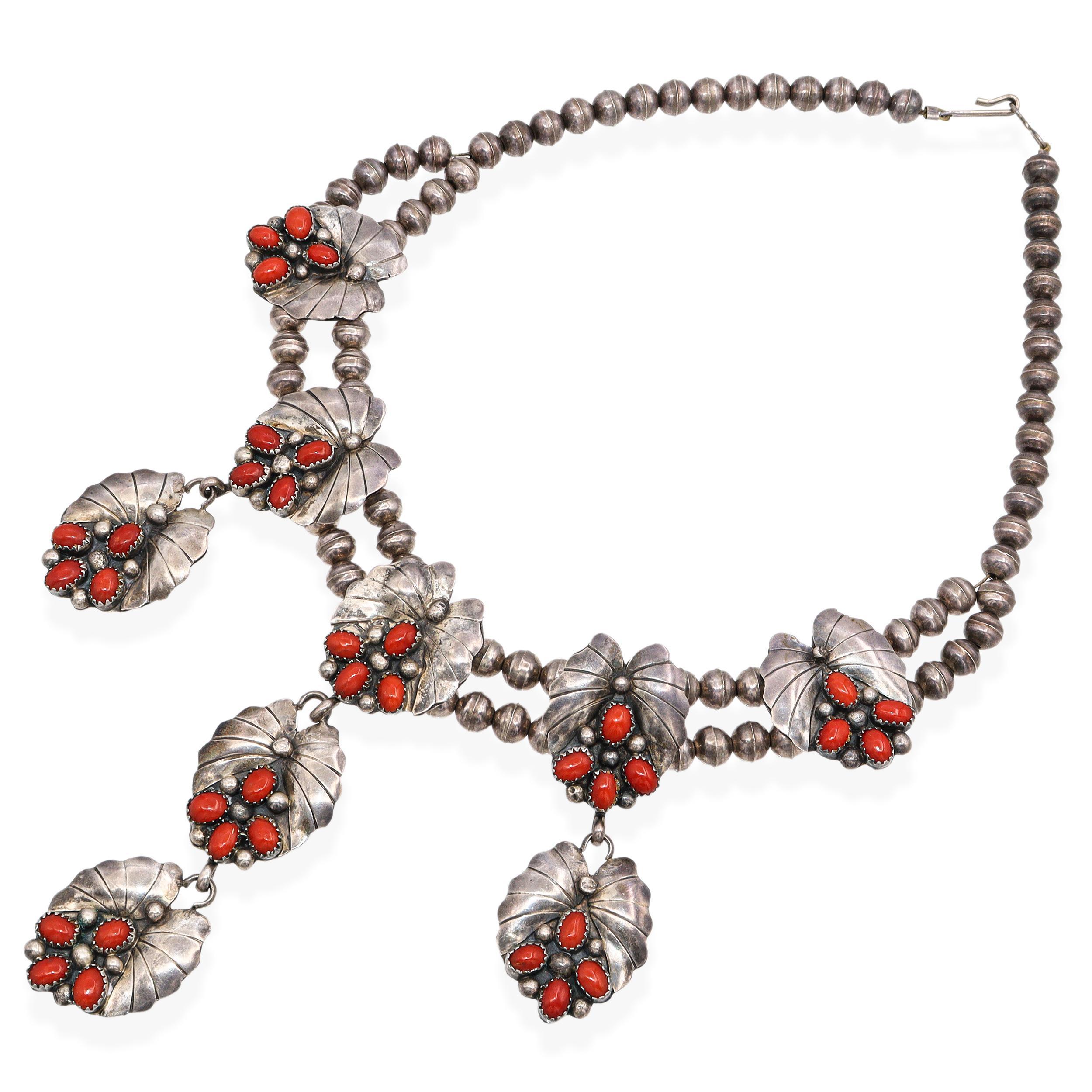 Collana vintage in argento sterling Navajo con bellissime stazioni a forma di foglia realizzate a mano con cabochon di corallo rosso naturale. Ogni pezzo è dettagliato con la tradizionale stampigliatura Navajo e mostra una patina calda e intatta che