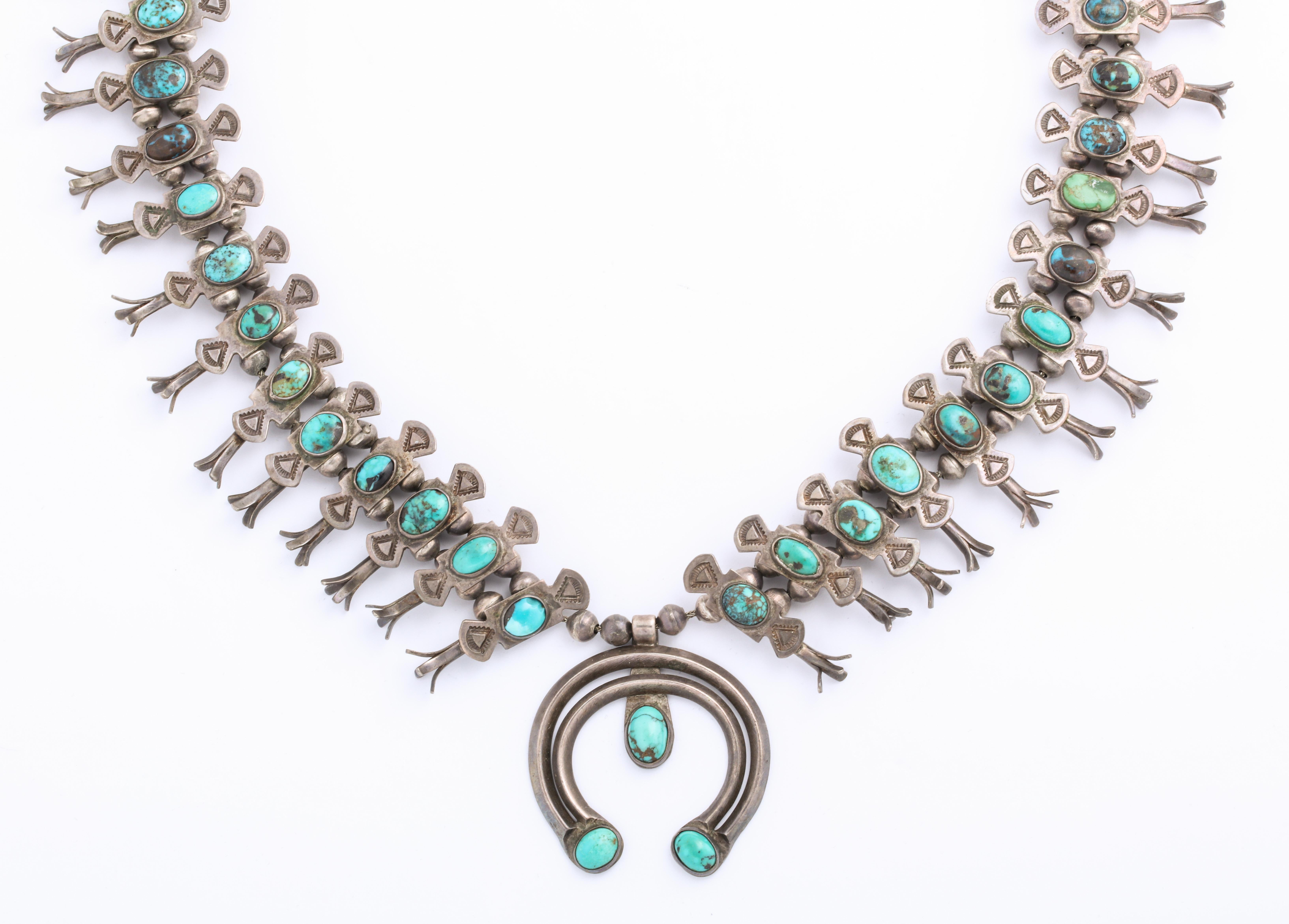 A magnificent and elegant Navajo Squash Blossom Necklace made by Eskie Tsosie c. 1940 places a display of graceful, handmade squash blossoms around your neck. The blossoms hold natural turquoise.. Rarely do you find a squash blossom necklace this