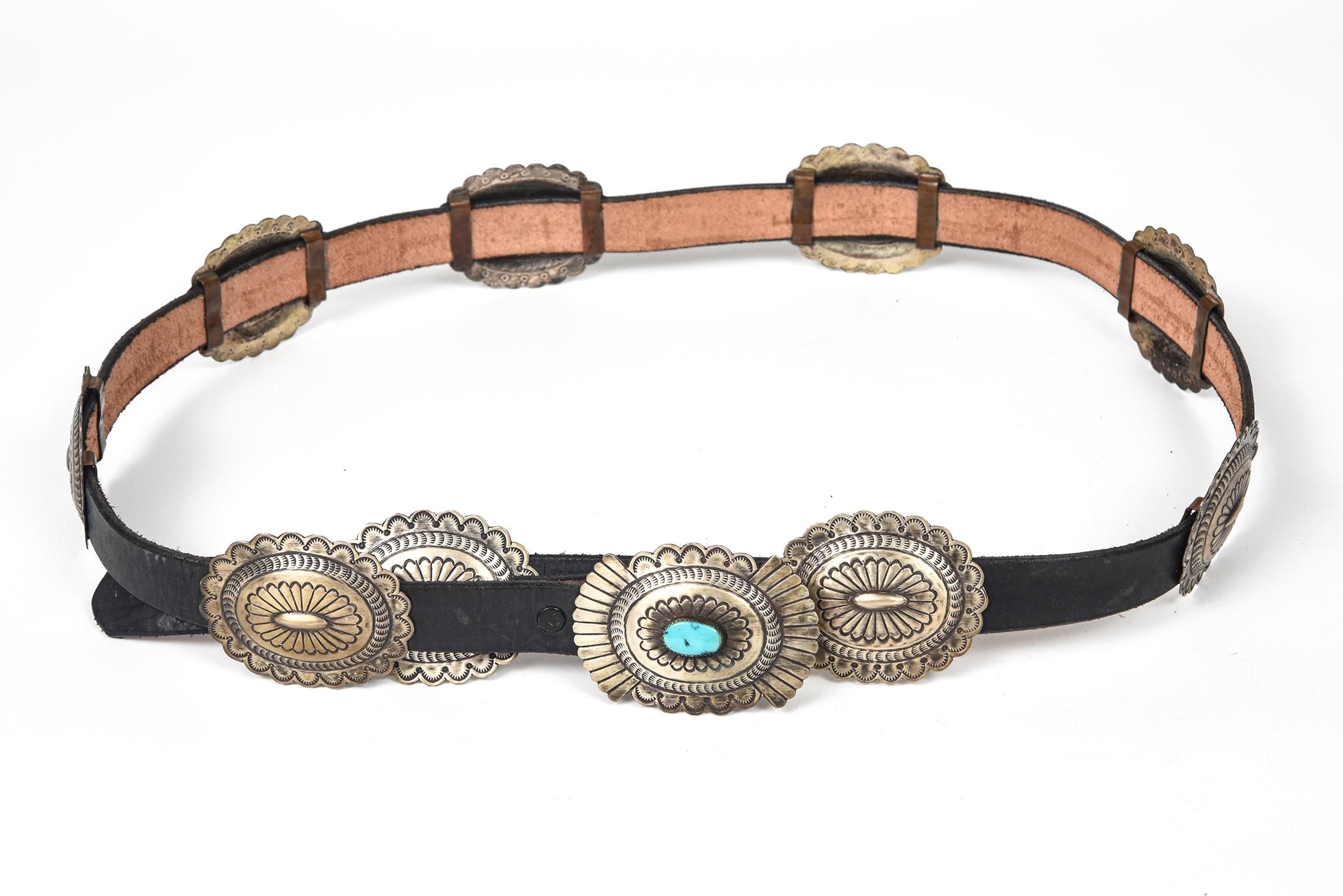 This beautiful handmade Concho belt was purchased in 1990 and never worn.  It features 9 sterling silver oval stylized conchos each measuring 2.5″ x 2″ and a matching buckle with a centrally set oval cabochon turquoise.  The buckle measures 2.80