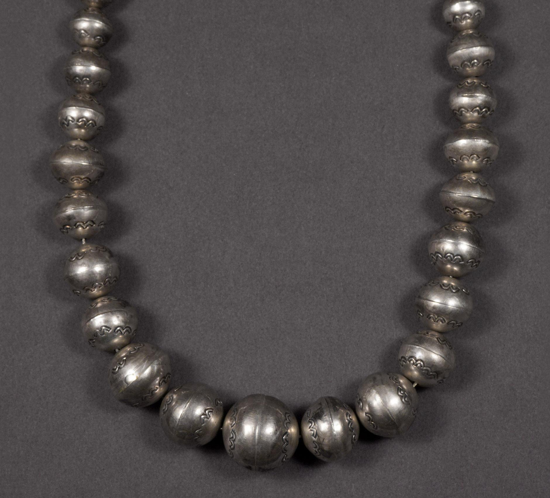 Vintage Navajo Sterling Silver Graduated Stamped Bead Necklace

A vanishing piece of history in Native American silver “Pearls”  necklace. An emblem of prestige, silver cone endings and traditional clasp with old natural patina.