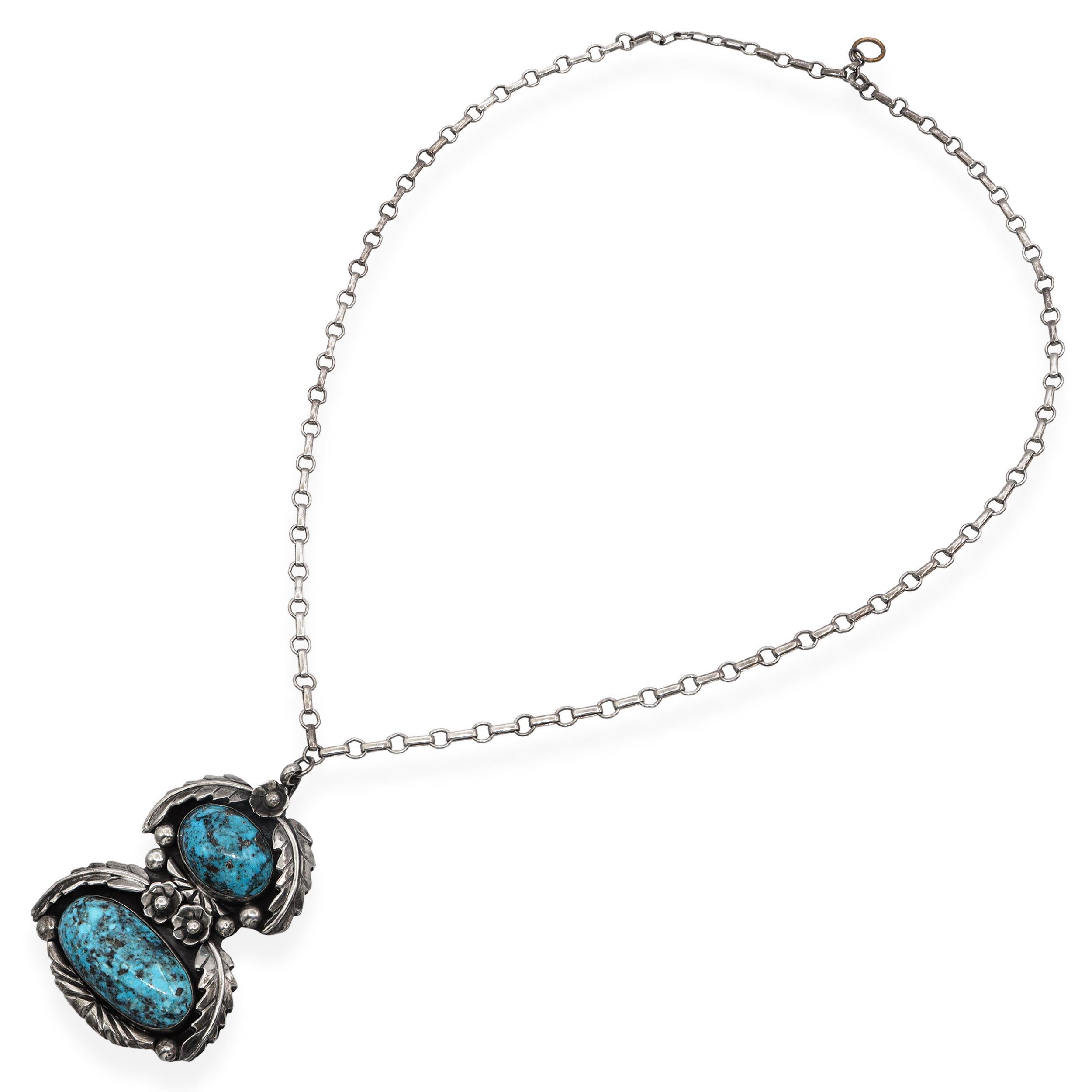 Questa straordinaria collana Navajo vintage è una creazione firmata dall'argentiere Tom Willetto, realizzata in argento sterling e con due vibranti cabochon di turchese. Le pietre presentano bellissimi motivi a matrice, ognuna incastonata in un
