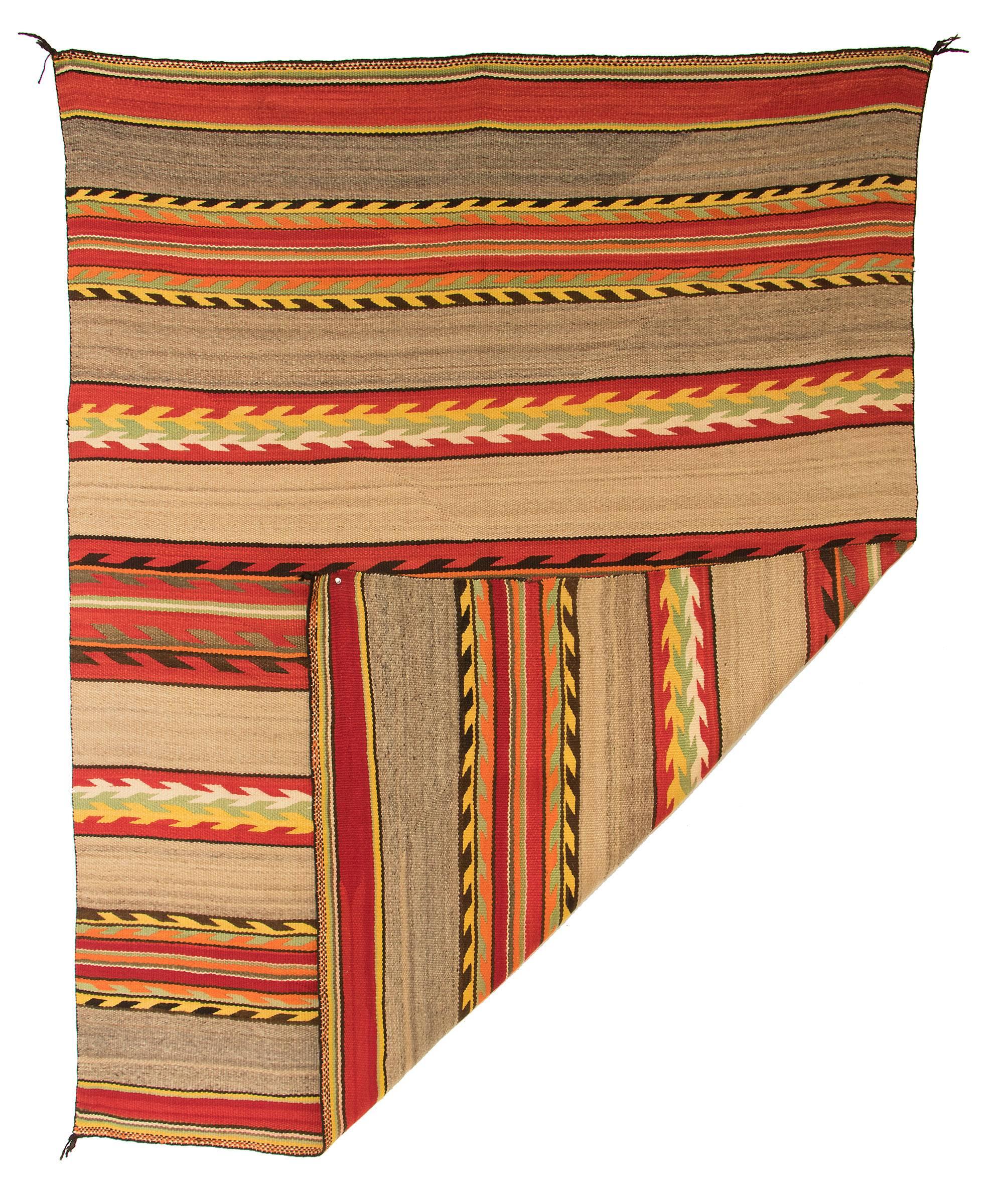 An antique Navajo transitional blanket, circa 1875-1900, this textile is woven of native hand-spun wool in a banded and serrated design of natural fleece colors of brown, grey and ivory with aniline red, yellow and green. This textile is well suited