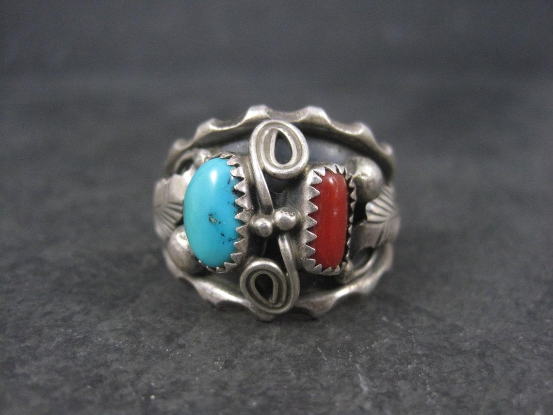 This gorgeous vintage Southwestern ring is sterling silver with natural turquoise and coral stones.

The face of this ring measures 13/16 of an inch north to south with a rise of 6mm off the finger.
Size: 13
Weight: 10.2 grams

Marks: Sterling, C