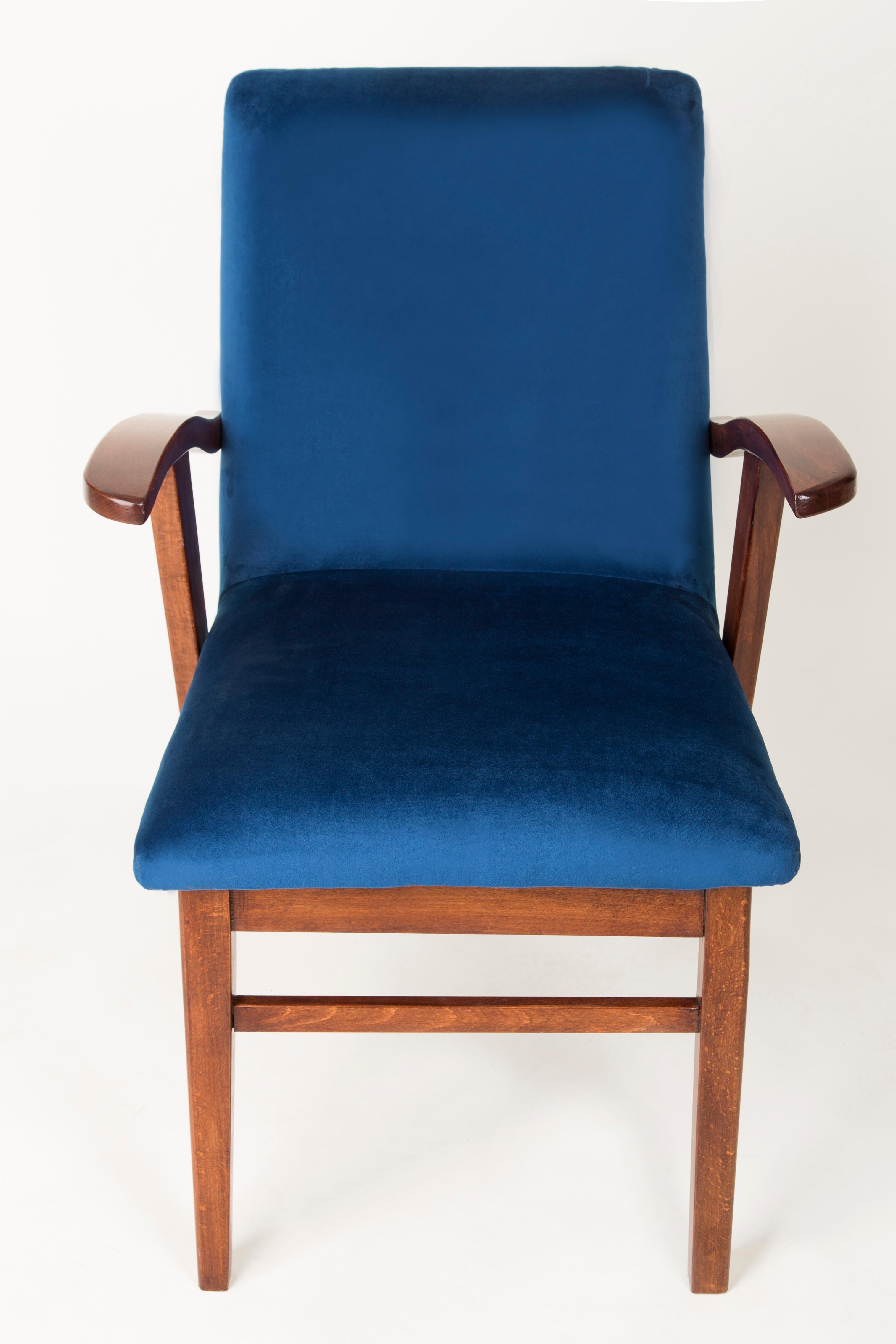 Armchair designed by Mieczyslaw Puchala in a Classic edition. Dark wood combined with a navy blue fabric gives it elegance and nobility. The chair has undergone a full carpentry and upholstery renovation. The wood is in excellent condition -