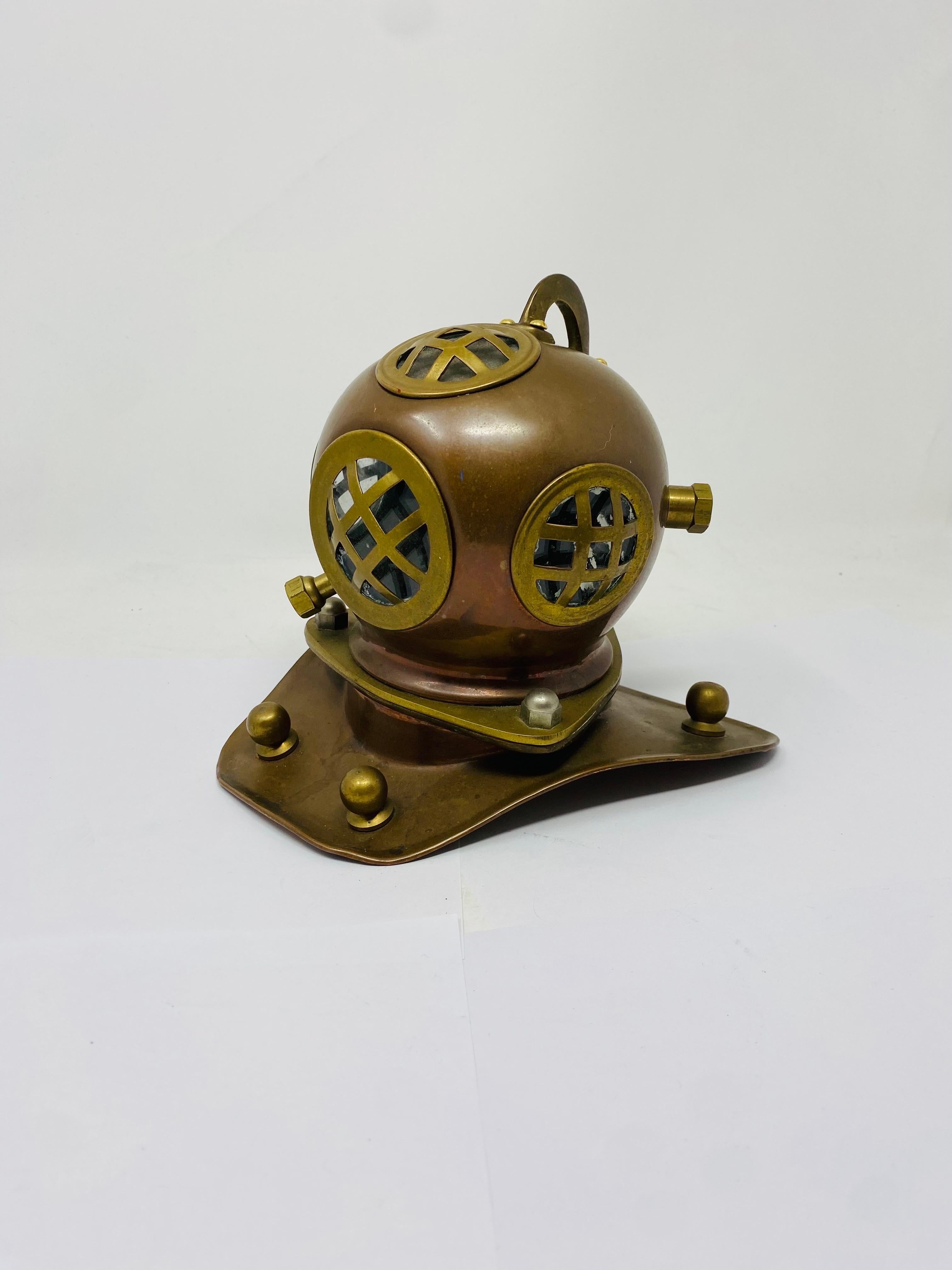 Interesante y encantadora escultura de casco de buceador que capta el estilo y la herencia que encarna.  La pieza está creada con varios metales y detallada  al tiempo que manifiestan un aspecto que juega con estilos de mediados de siglo hasta