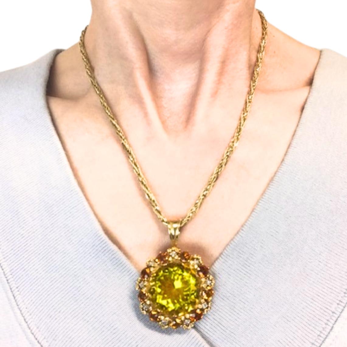 Collana vintage in oro 14k con un ciondolo rotondo con una gemma gialla vibrante, probabilmente un citrino, circondato da piccoli diamanti e altre pietre arancioni. La disposizione dei colori aggiunge dimensione e contrasto, attirando l'attenzione