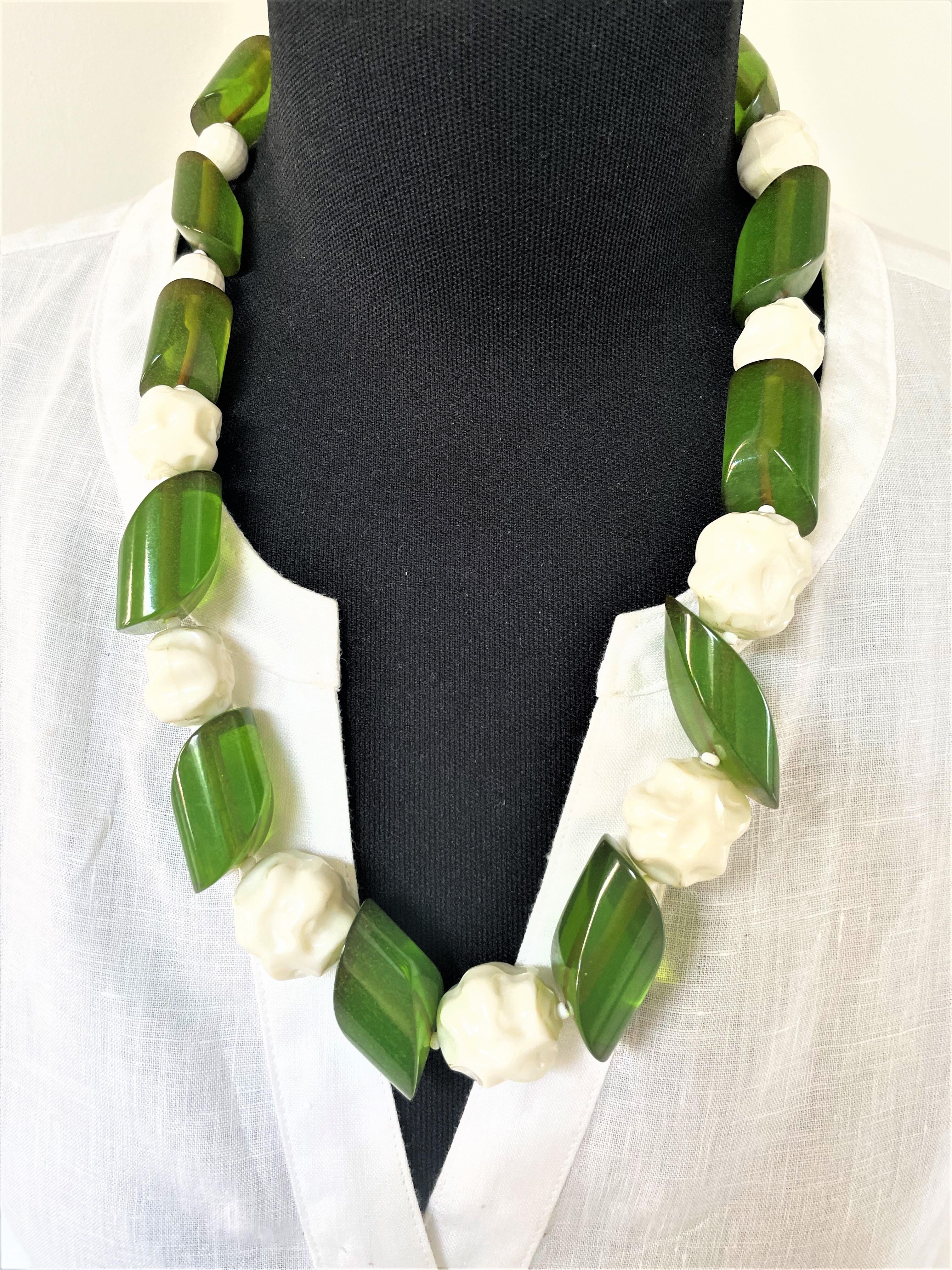 Contrasting 60 cm long chain consisting of green transparent , tubular, diagonally cut parts, possibly Bakelite and white plastic balls. This necklace coms from the USA. Very decorative, very comfortable to wear in terms of weight. The green oval