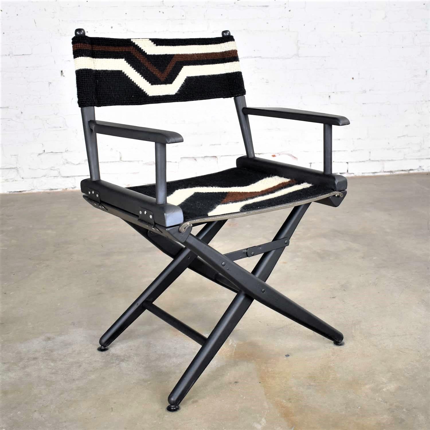 Awesome black wood folding director’s chair with a handmade black, brown, and white geometric pattern needlepoint sling seat and back. It is in wonderful vintage condition. The wood has a new coat of black paint. The needlepoint is all intact and