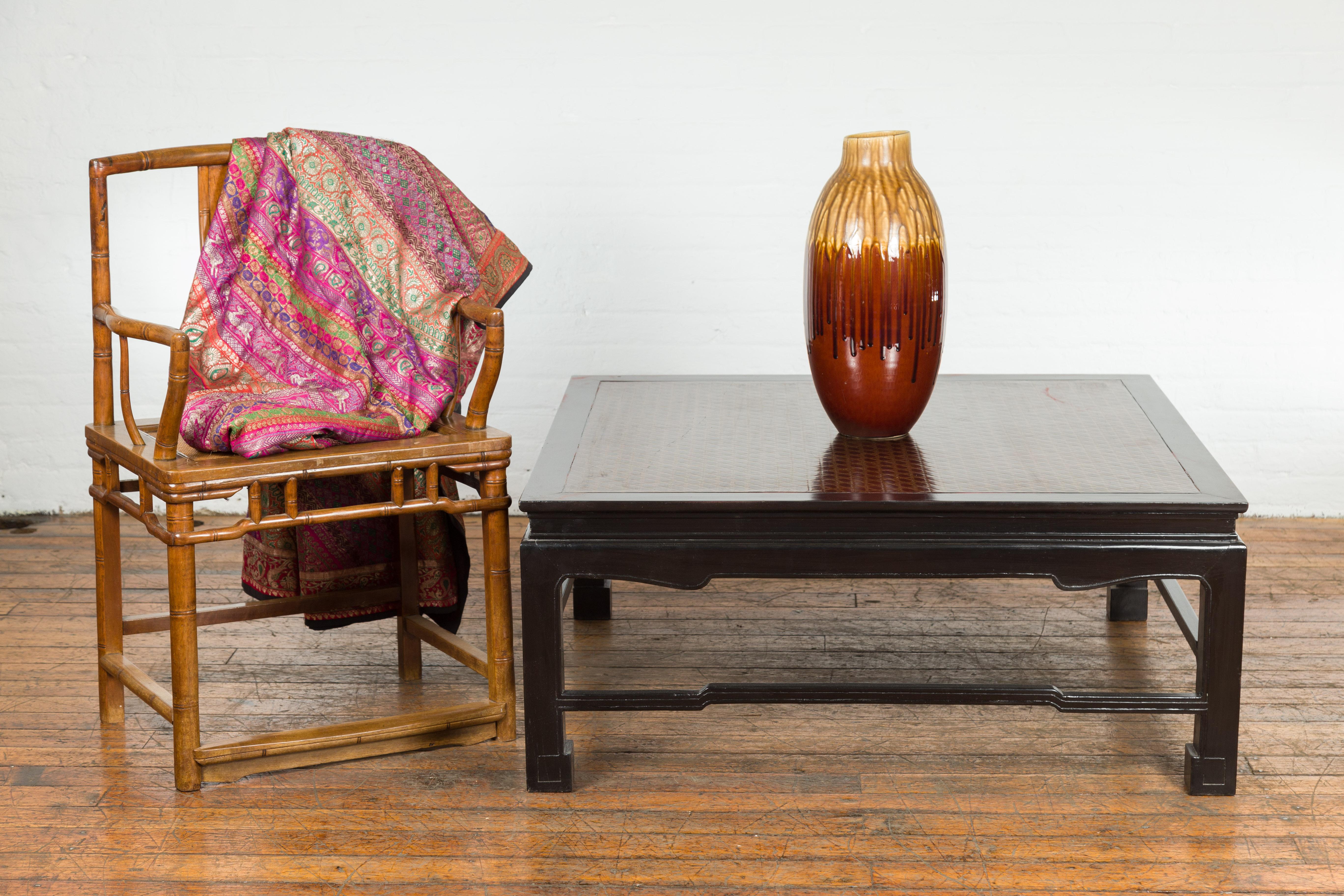 A vintage black lacquered coffee table from the mid 20th century with Negora lacquered top. This vintage mid-20th century coffee table is a tribute to the timeless elegance of Asian design and the mastery of Negora lacquer work. Exuding understated