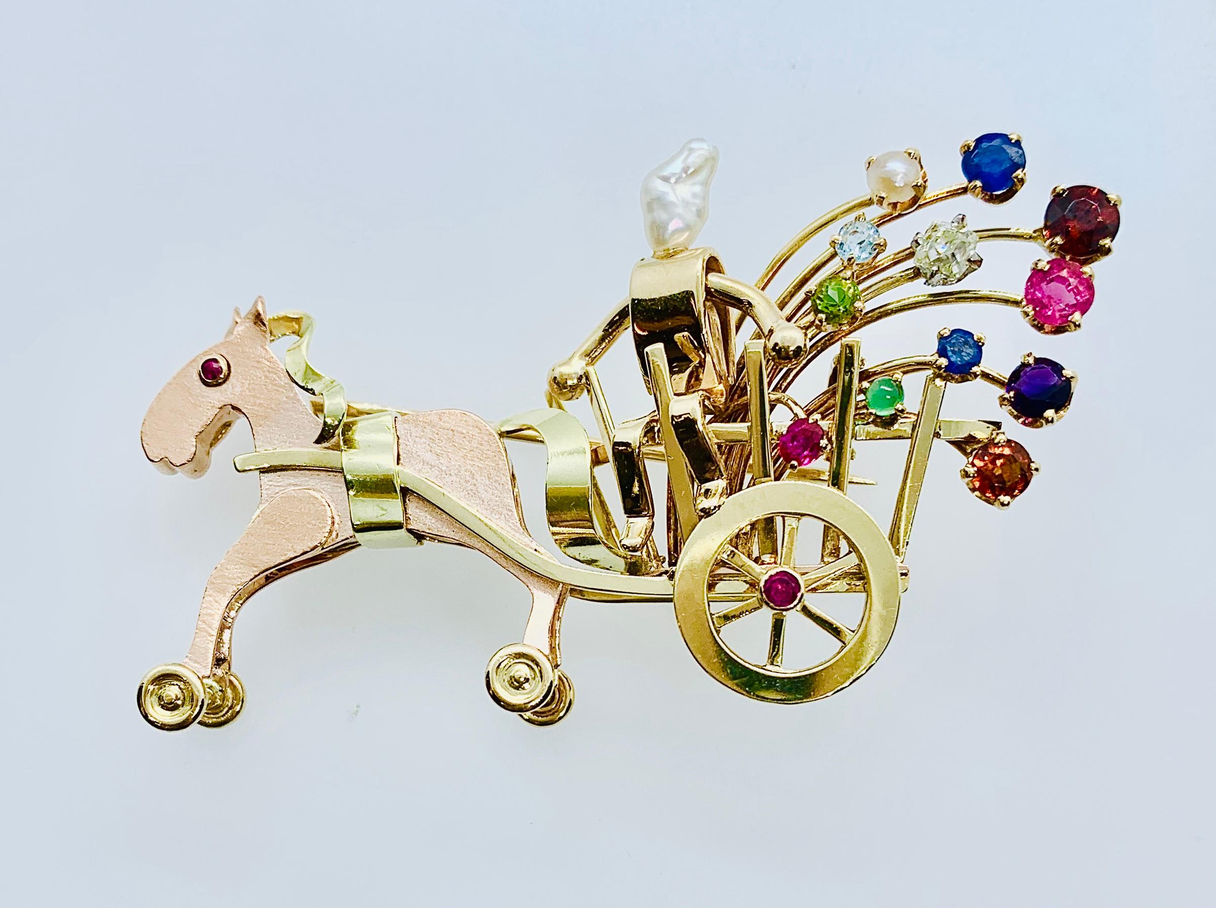 Gorgeous and so whimsical Horse and Carriage Brooch! Designed by Neiman Marcus, this piece is made in 14K Yellow & Rose Gold. The wheels actually turn. The piece has 13 colored gemstones and one old mine cut diamond. The pice measures 2.25 by 1.25