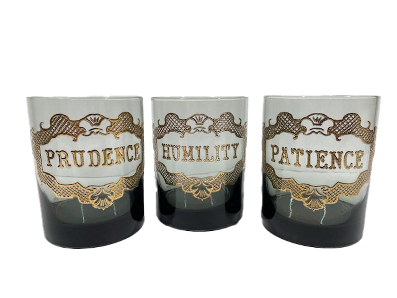 Six mid-century rocks glasses private labeled for and marketed by Neiman-Marcus having the name of a virtue within an elaborate cartouche in 22k gold on smoked glass.