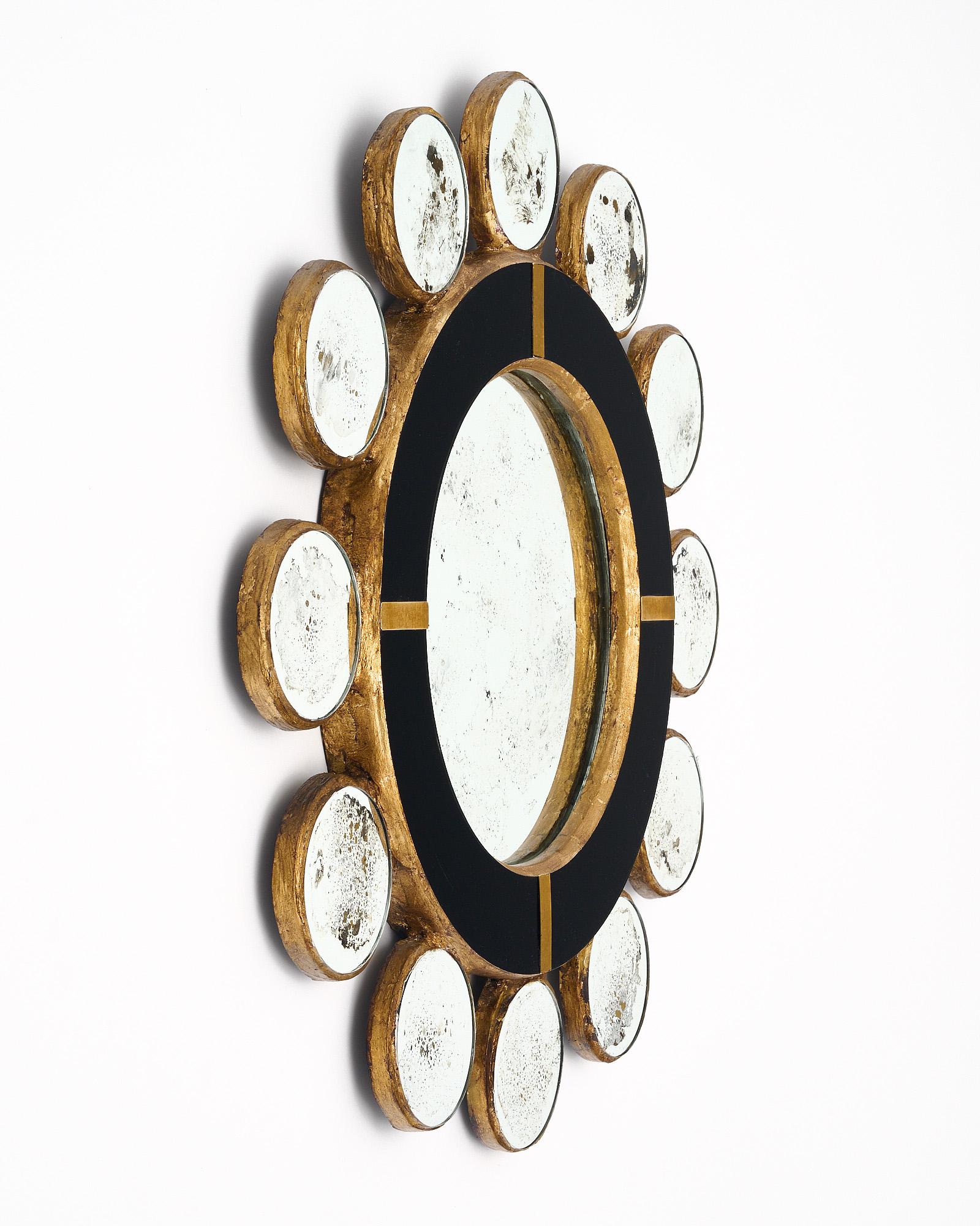 Mirror, from Spain, with a gold leafed wooden frame that has been veneered with opaline black glass. The central mirror is surrounded with eglomised spheric mirrors. Brass accents.