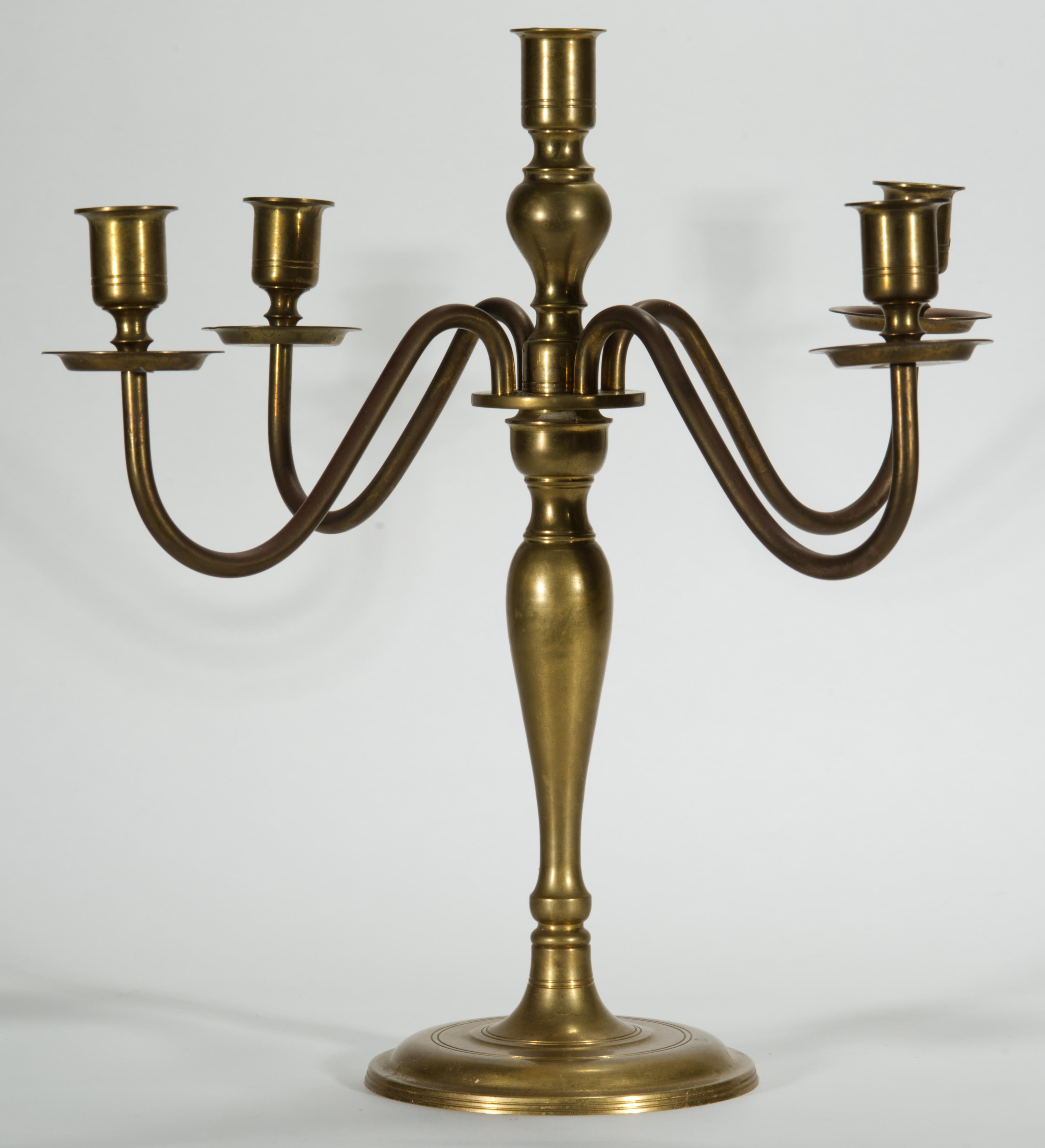 Candelabro in ottone vintage in stile neoclassico con quattro bracci scultorei e una base rotonda pesante e stabile. Ogni portacandela, tranne quello centrale, è dotato di una bobeche per evitare che la cera coli. 

Il candelabro è in ottime