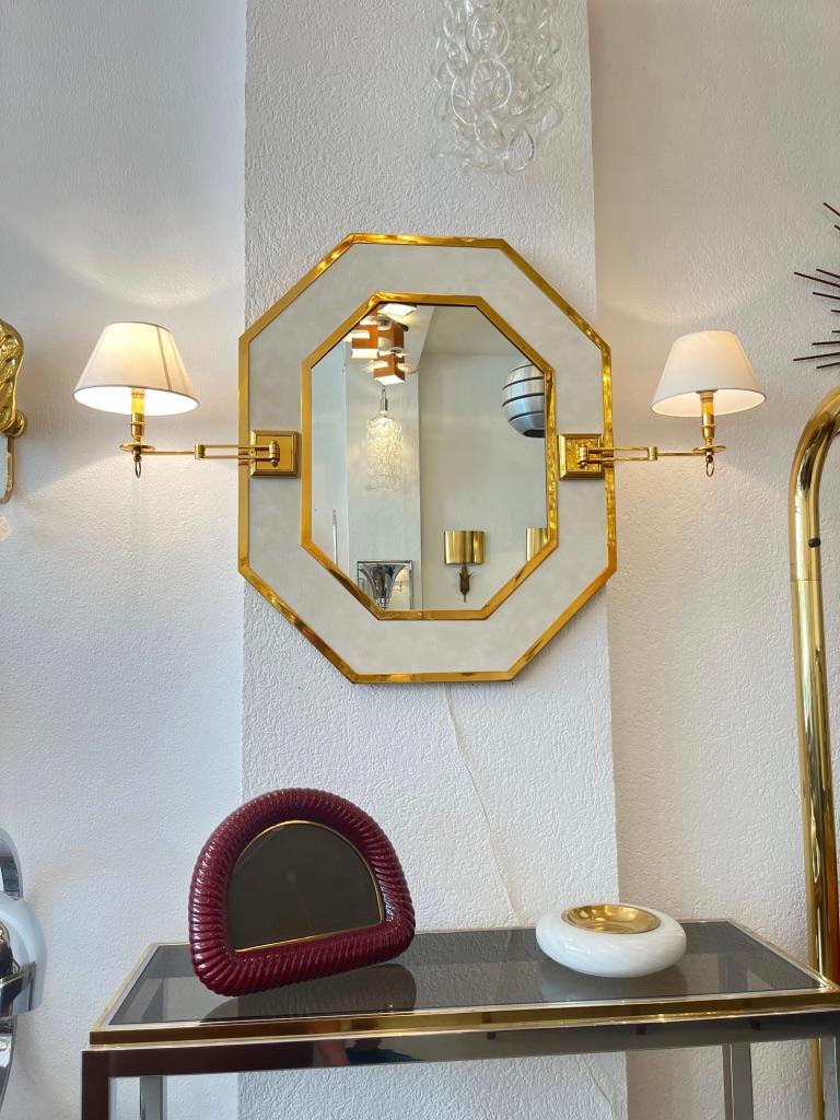 Decorative neoclassical brass and leather octagonal wall mirror with articulated sconces with paper shades.
Attributed to Jean Claude Mahey ca. 1970s.
Very good condition, new off white paper shades.
Easy to install and to plug.