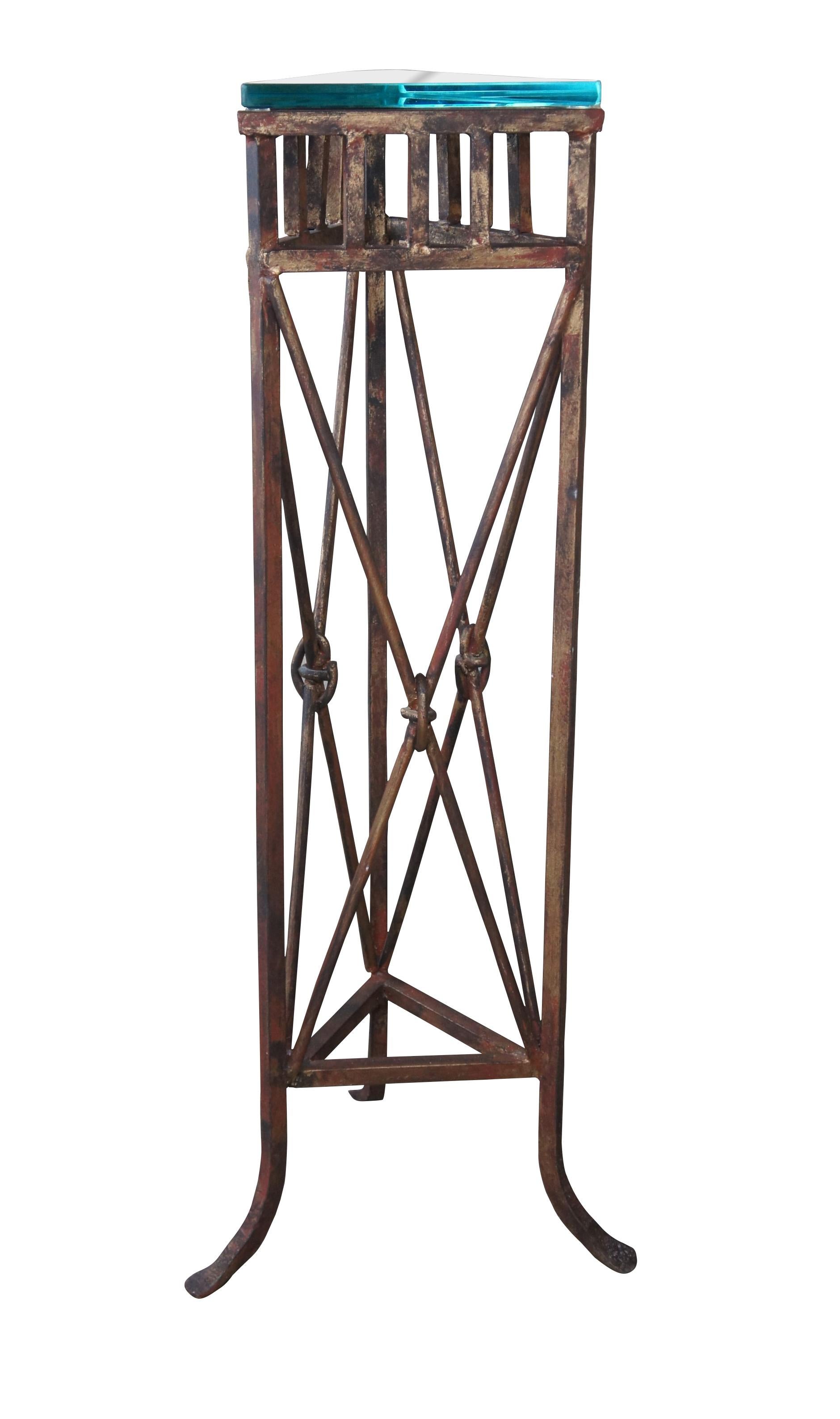 An iron pedestal in Neoclassical and French Empire styling. Features a reddish gold triangular prism form with 