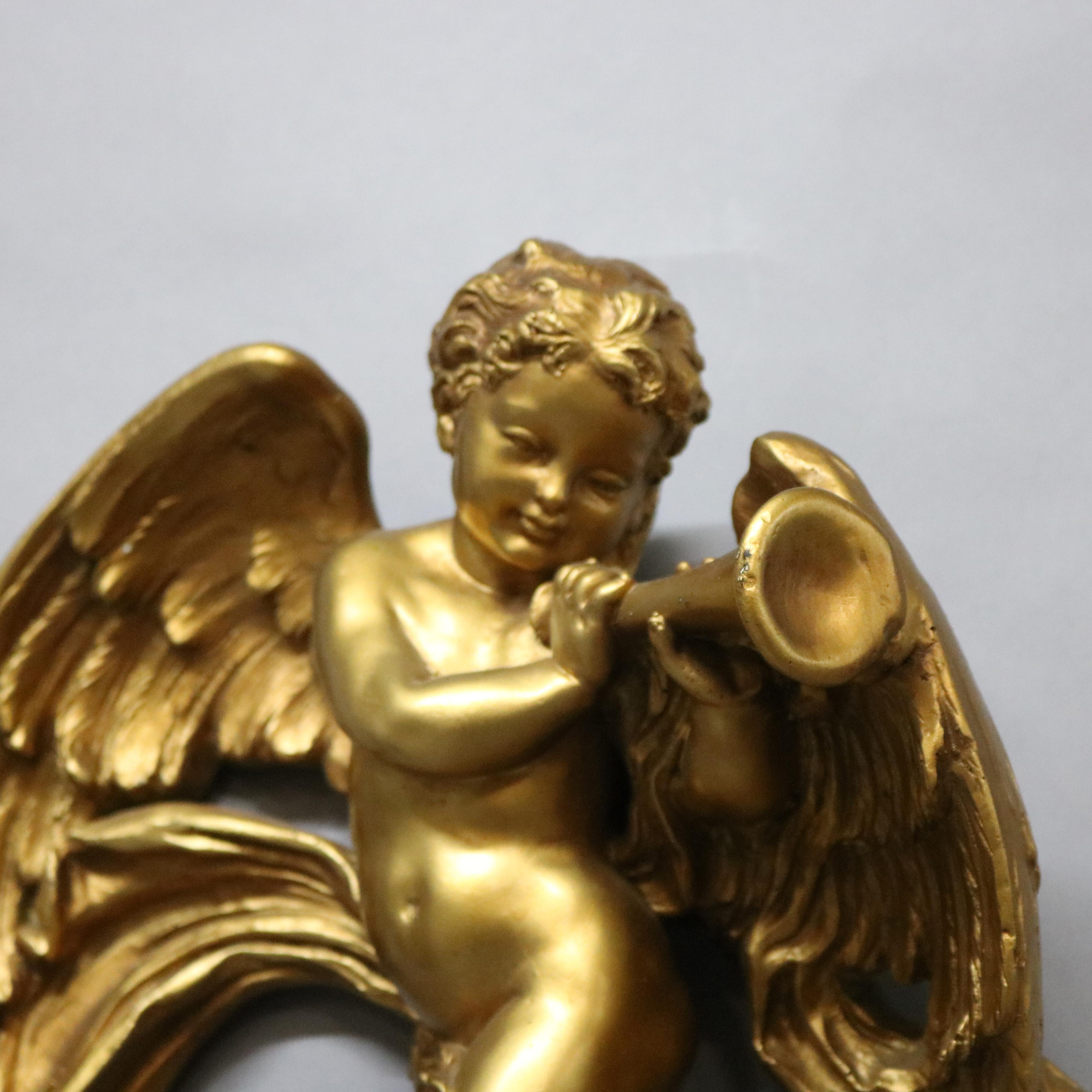 A vintage neoclassical wall sculpture offers gilt plaster construction and depicts a cherub or angel with horn and cloud, 20th century

Measures - 14.5