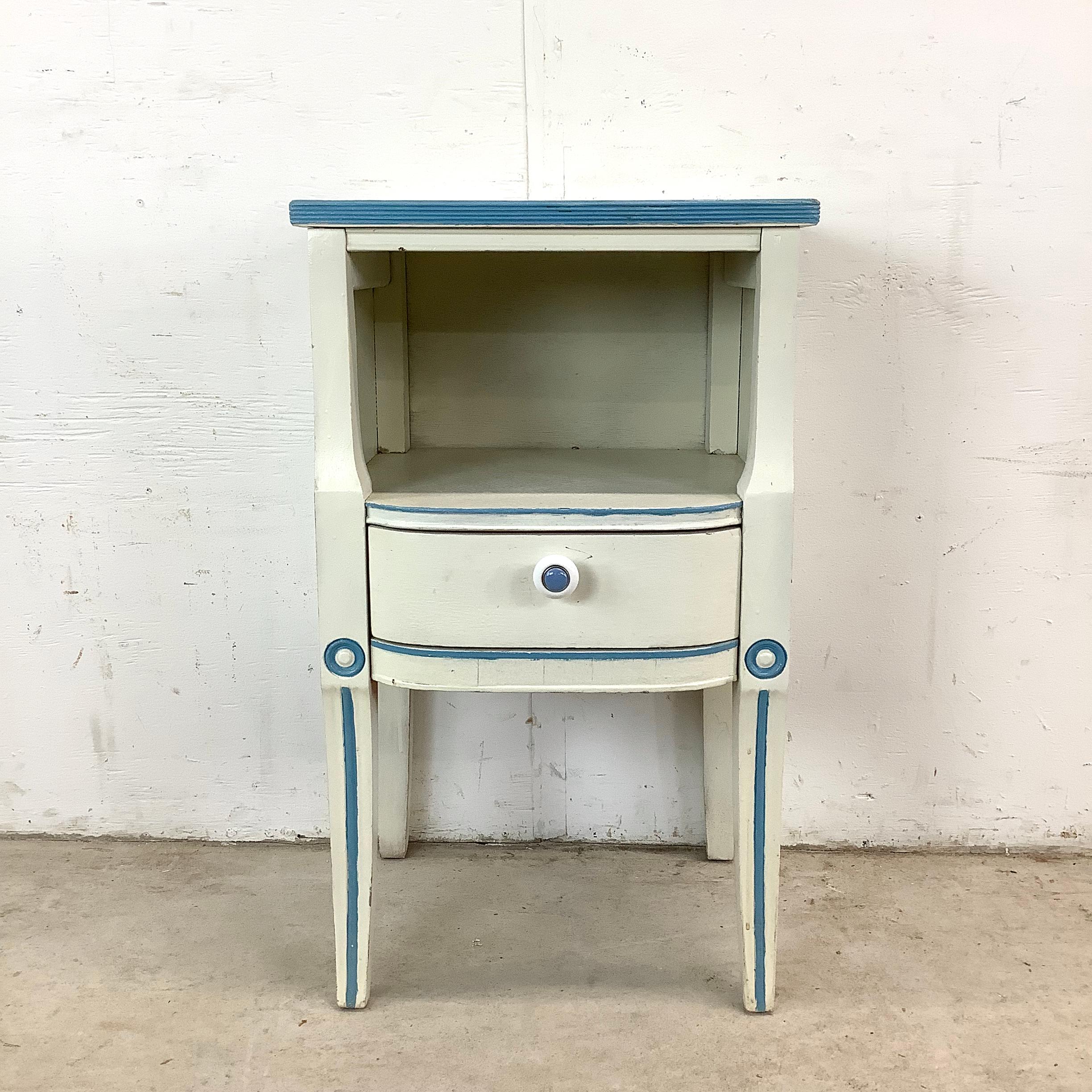This charming vintage nightstand reflects the refined elegance of Neoclassical and Gustavian design, with a soft distressed painted finish that adds both character and approachable warmth. Its shapely silhouette, graceful proportions, and subtle