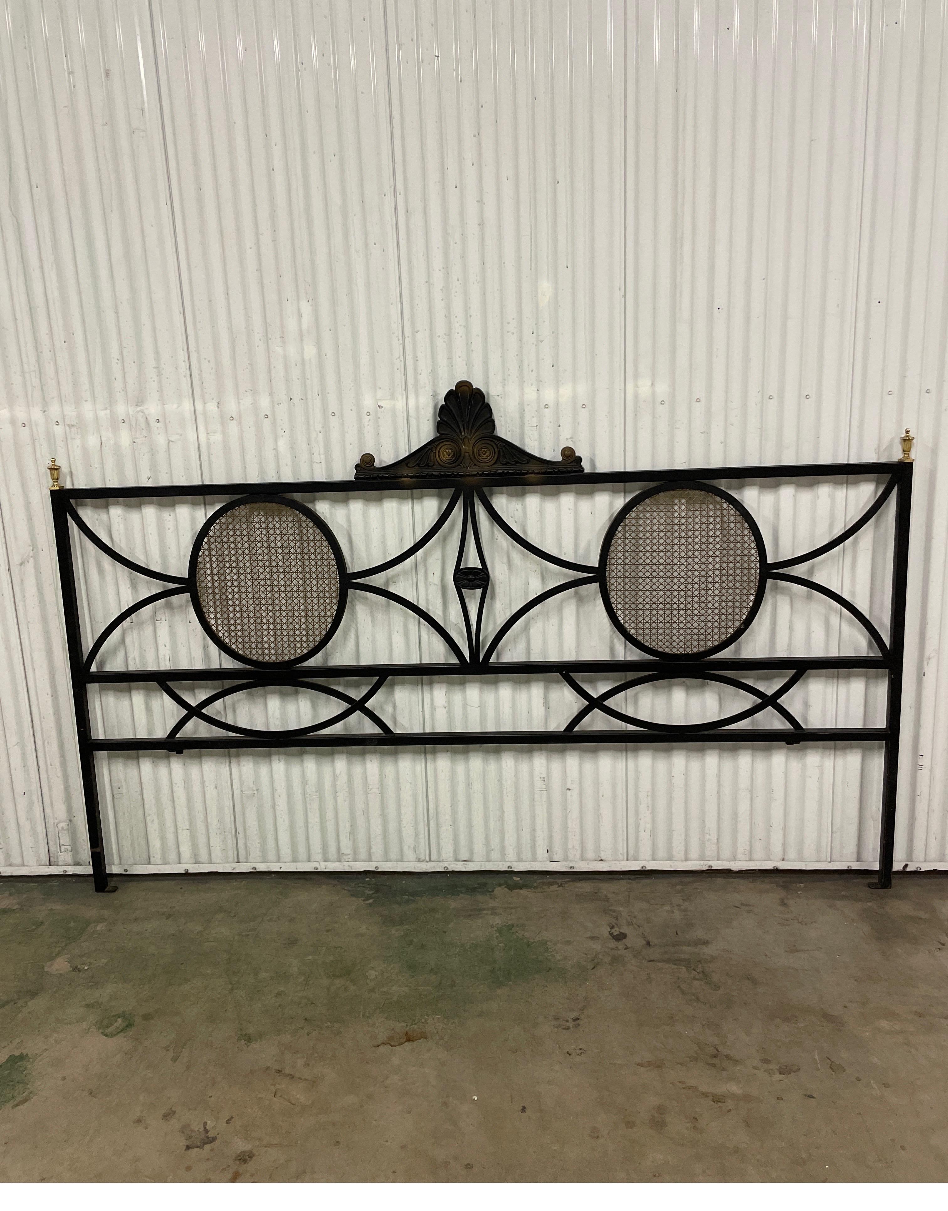 Vintage Neoclassical style King headboard in black wrought iron with gold metal caning and brass finials. 
