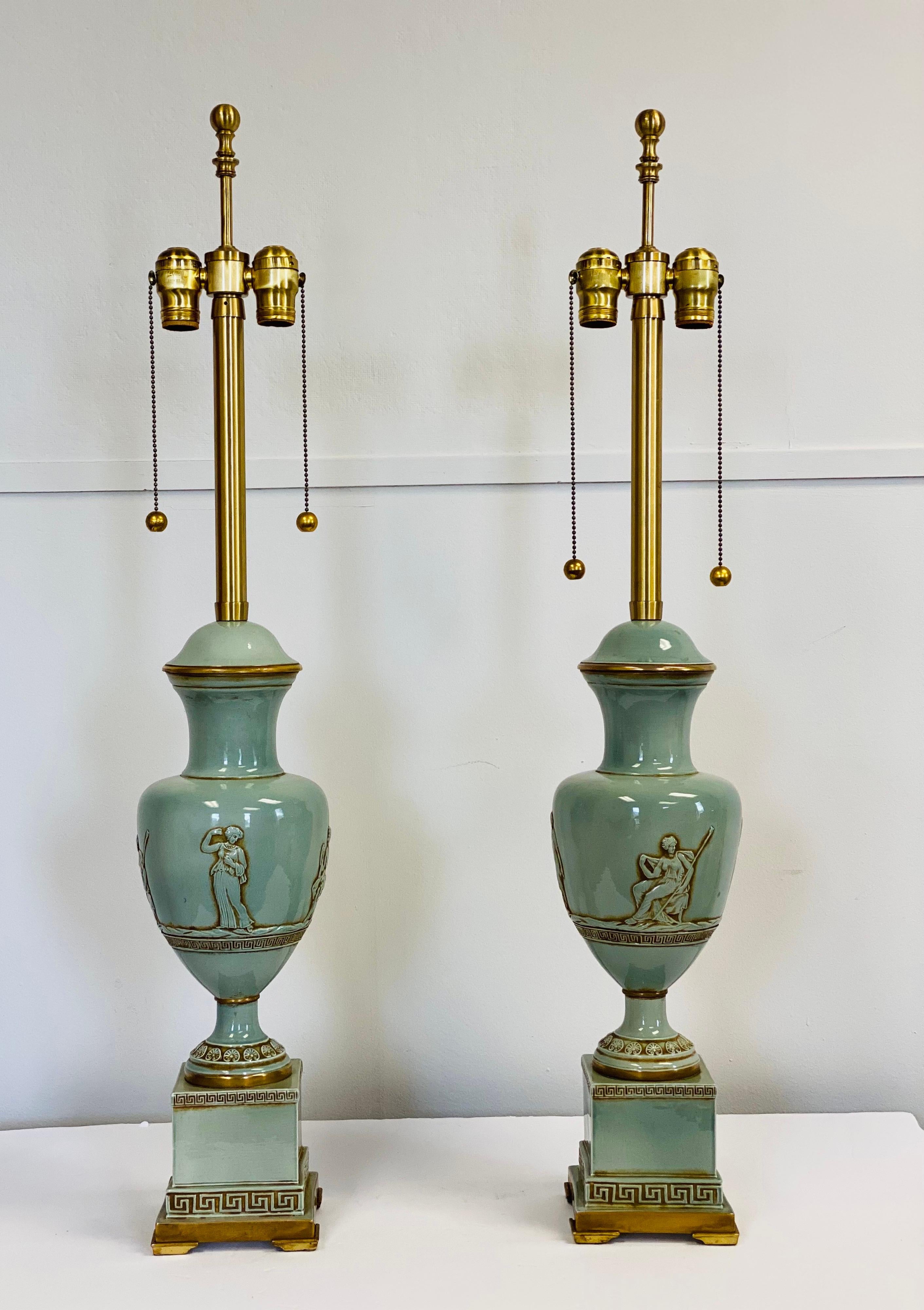 We are very pleased to offer an exquisite pair of lamps by The Marbro Lamp Company, circa the 1960s. A Classic ceramic urn profile with a glossy sage glaze is mounted on a square plinth with beautiful Greek key motif. Eye-catching intaglios depict