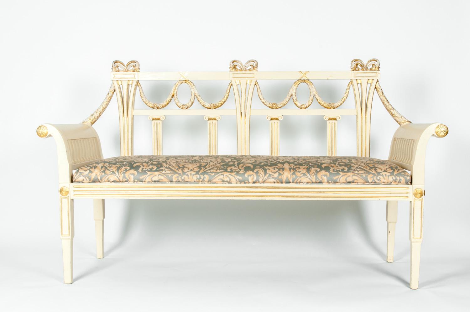 Vintage neoclassical style French settee or bench. This neoclassical style settee / bench was made in France with intricate Empire style wreath design and bow, fluted top column detail accented with gold leaf. The settee / bench measure about 58